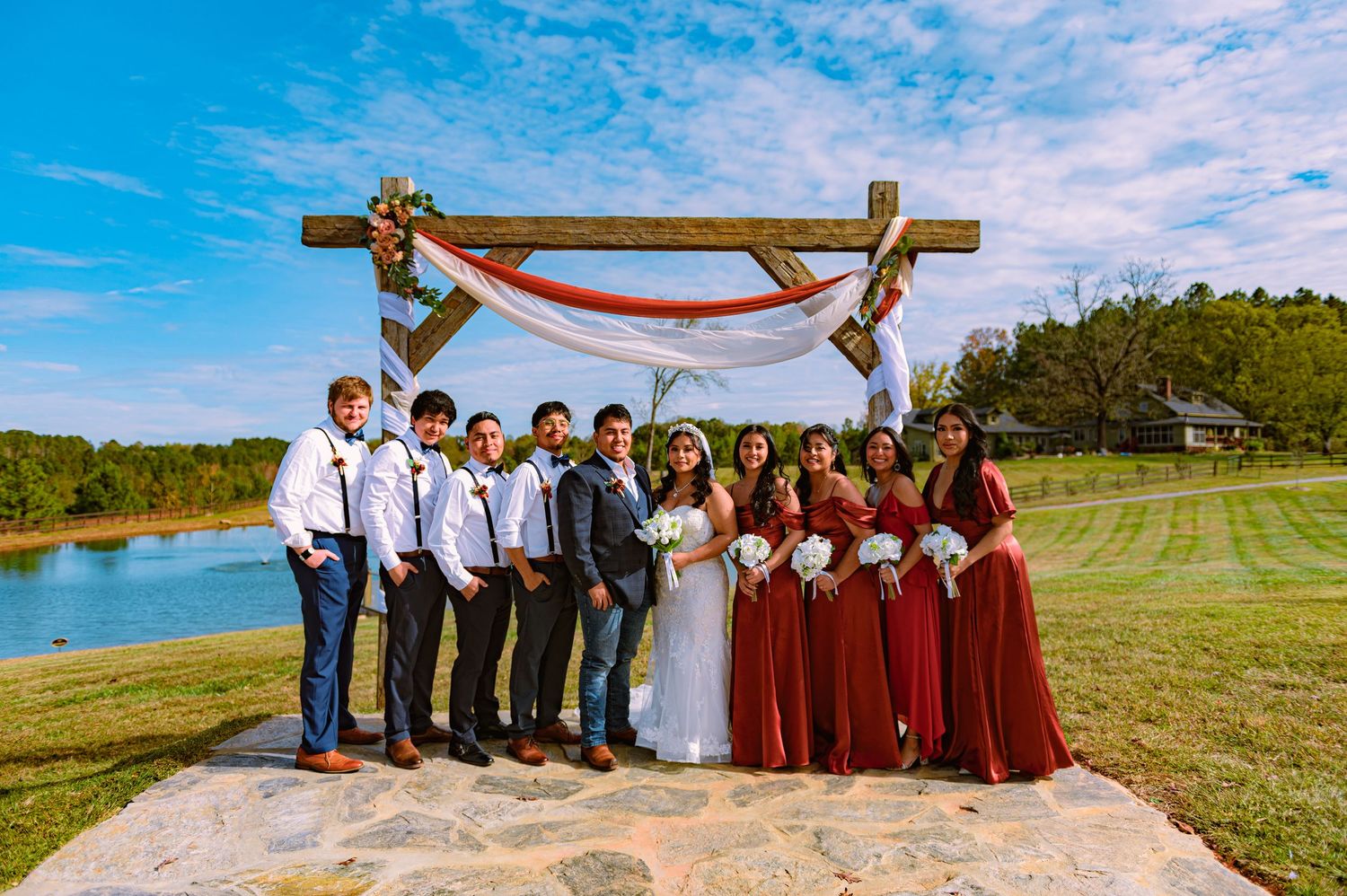 Wedding party members arranged in groups outdoors against scenic backdrops with rolling hills and blue skies.