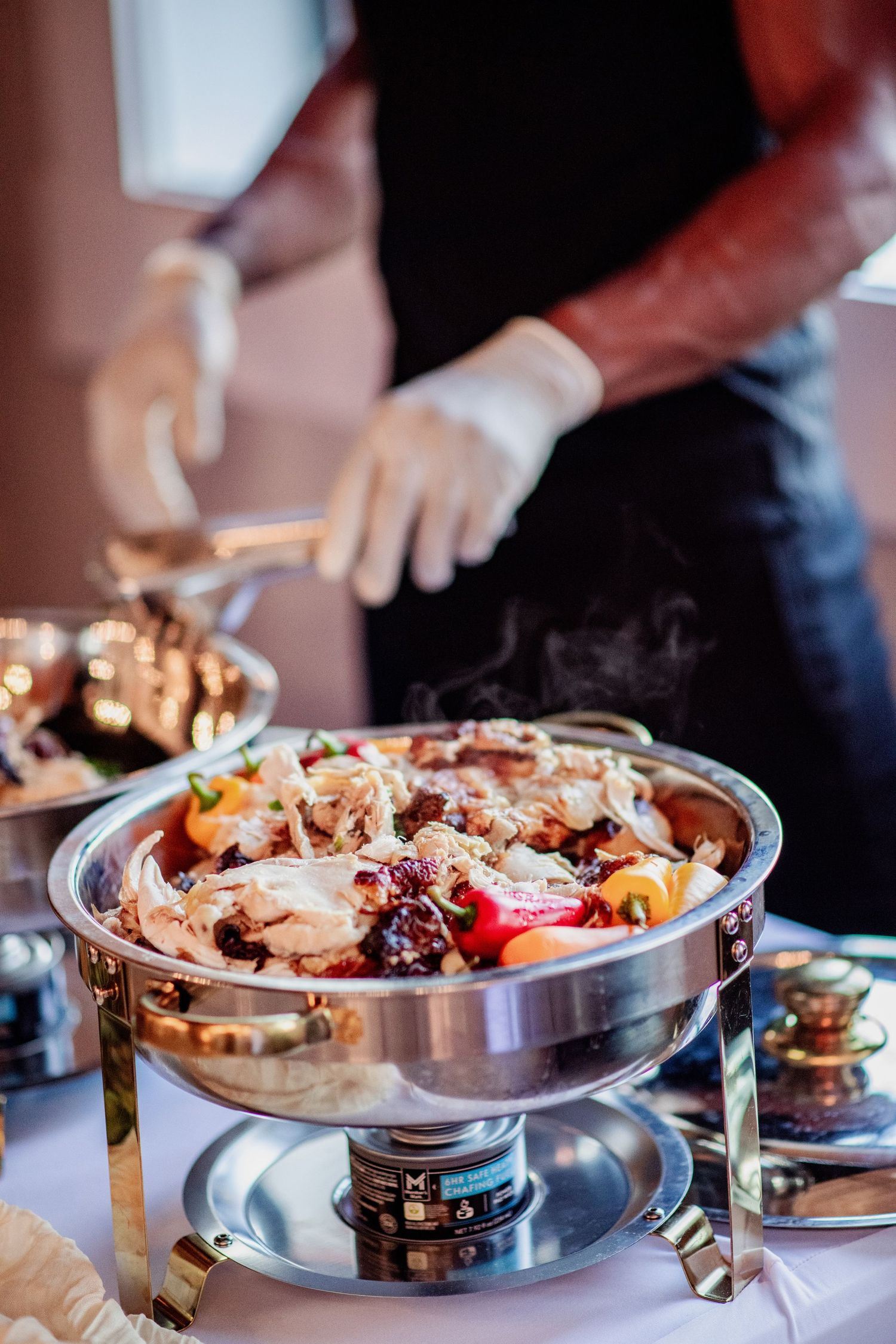 Buffet style wedding reception food displayed in silver chafing dishes.