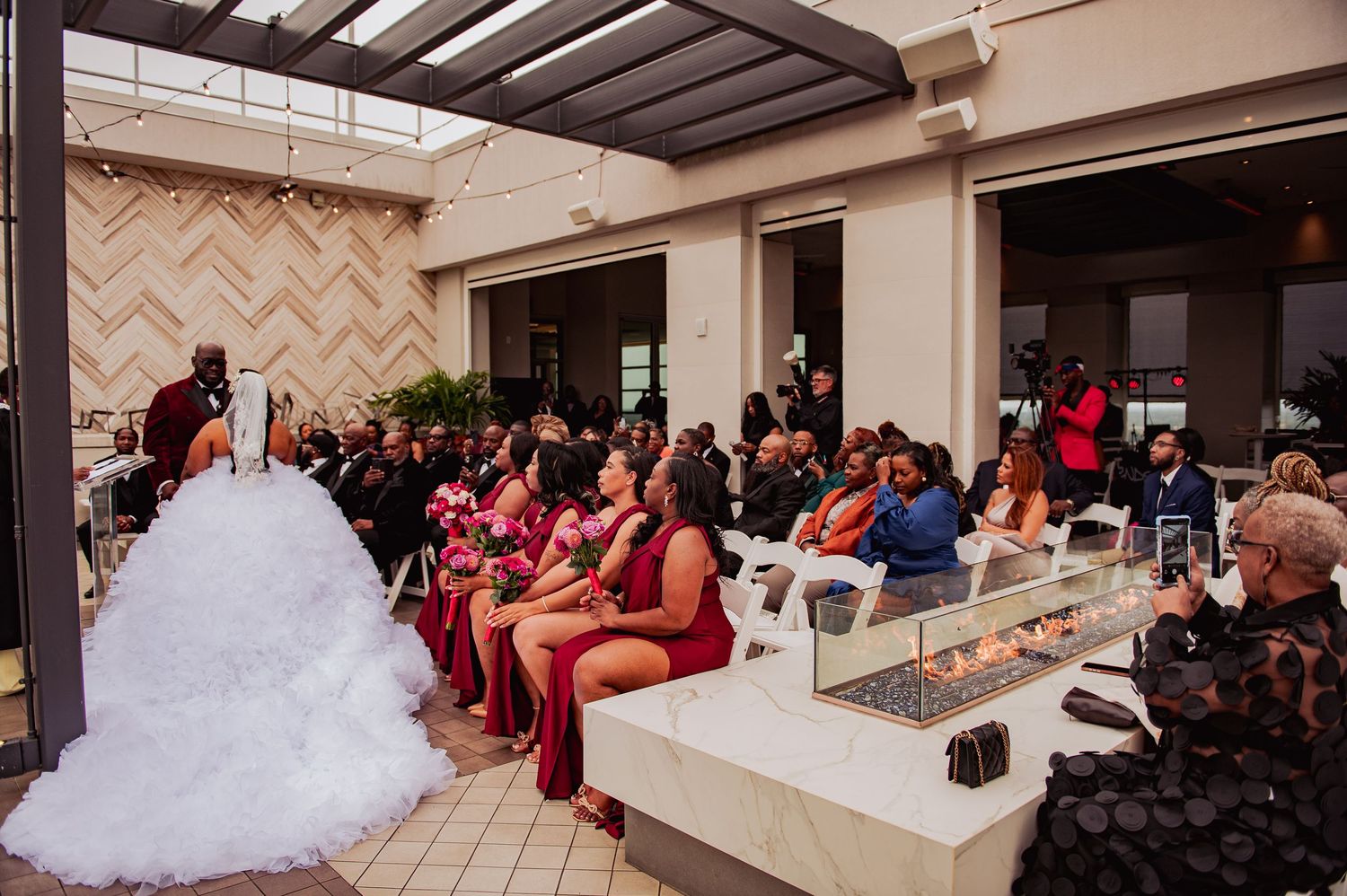 A panoramic view of a wedding reception venue with elegant decor and guests seated at tables in a banquet hall.