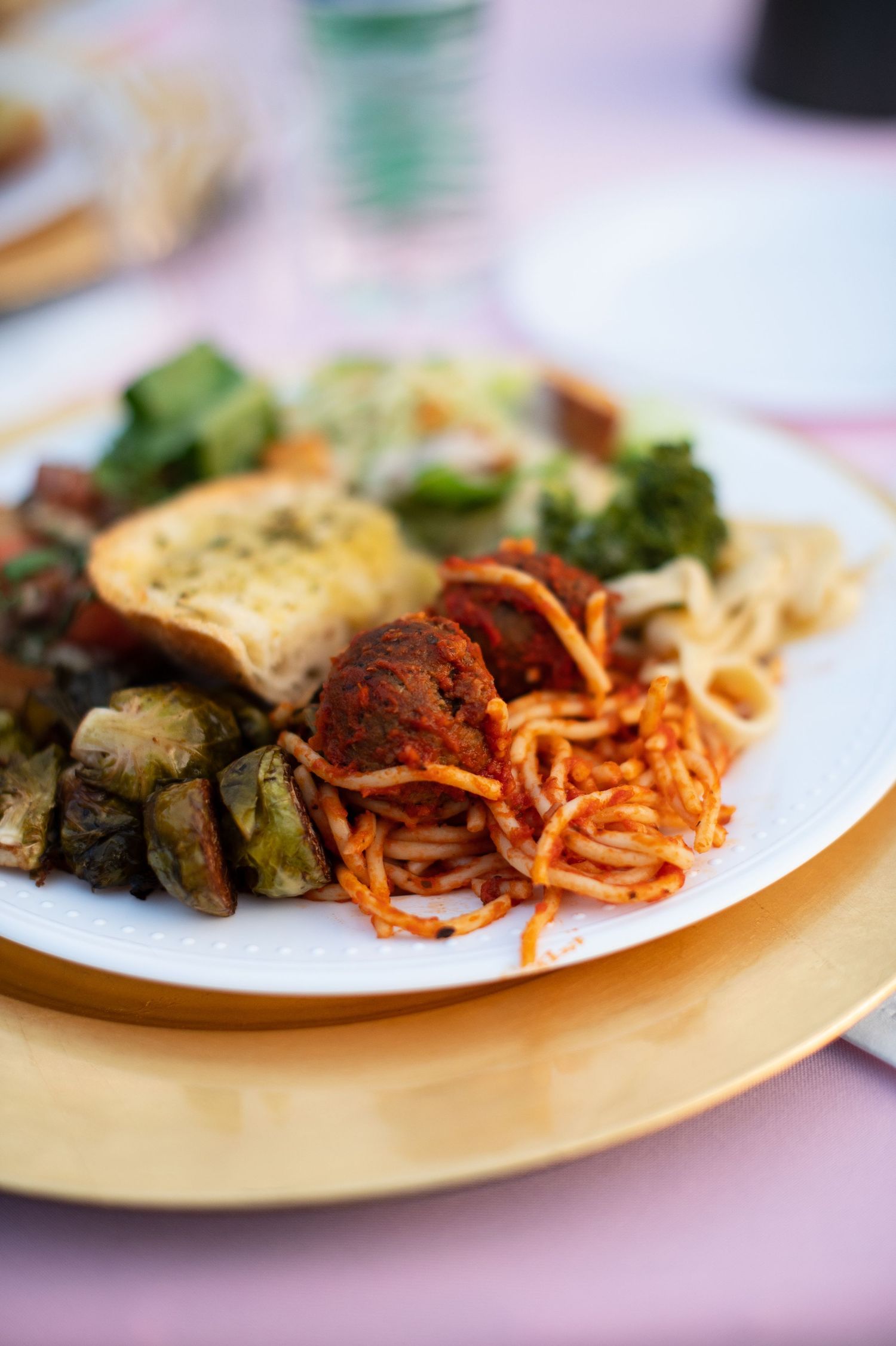 Dinner plates served with spaghetti pasta, roasted vegetables and garnish on white plates.