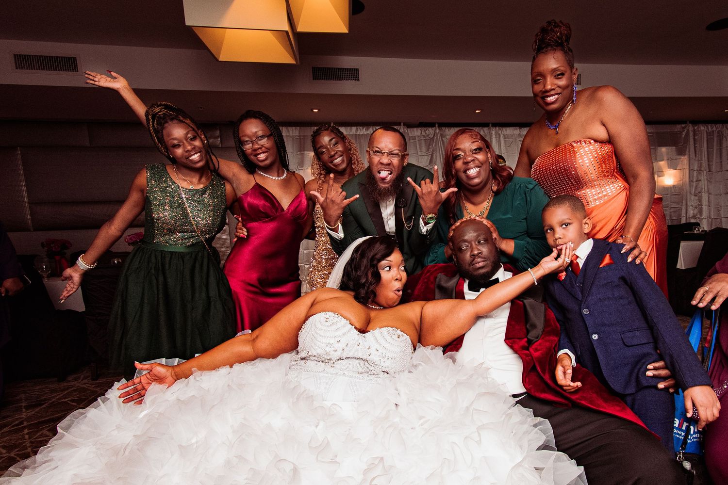 Wedding party members slide across a dance floor during a fun reception celebration.