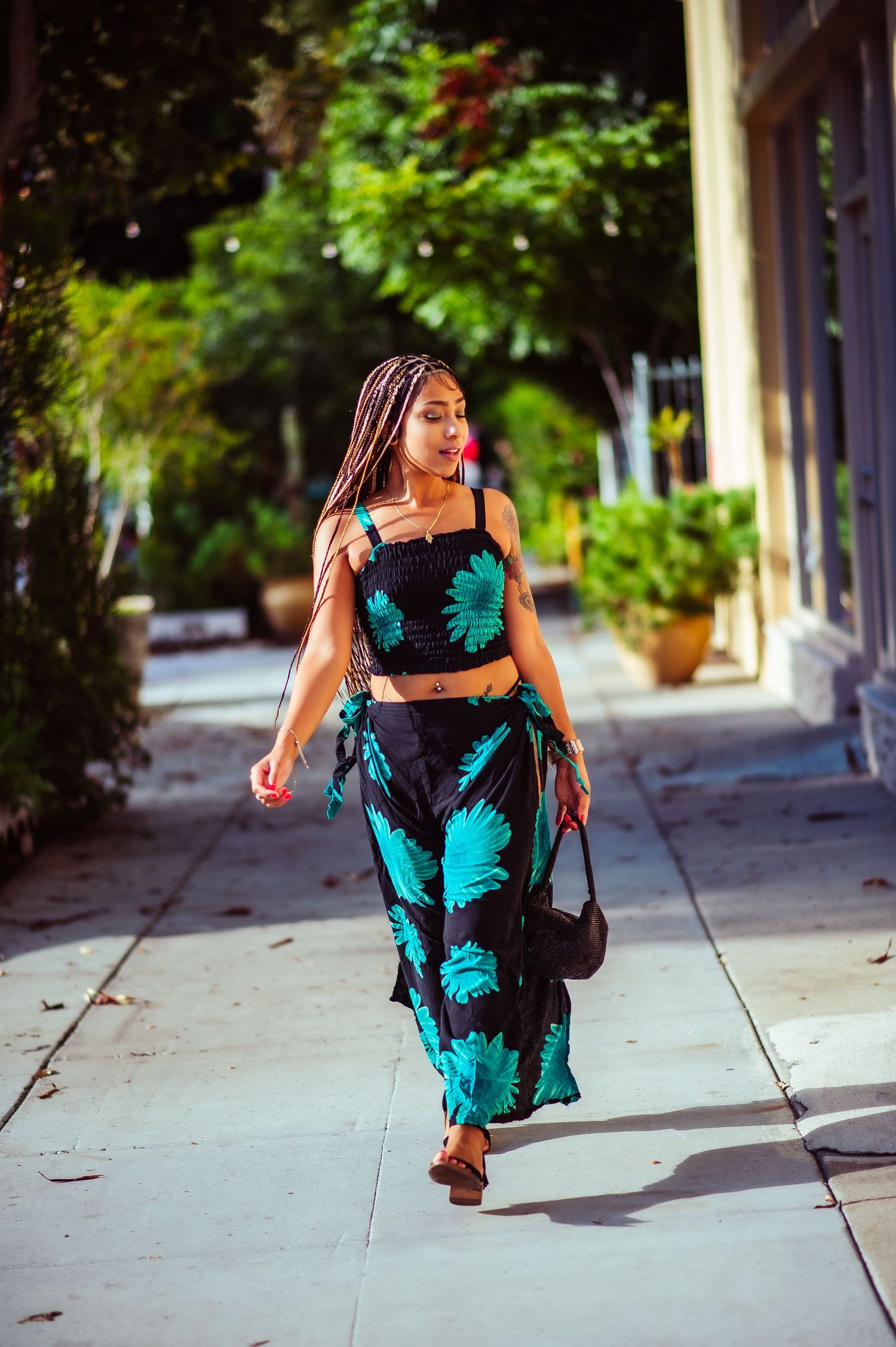 A stylish black and turquoise floral dress captured in a series of outdoor photos against a tree-lined street.