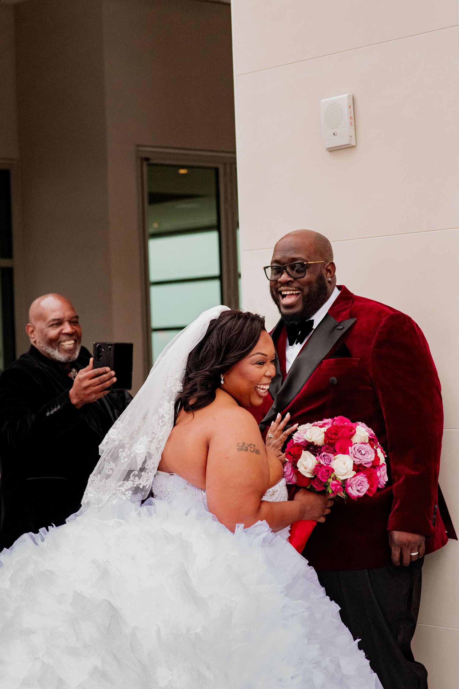 Joyful wedding couple laughs together during outdoor photo session.
