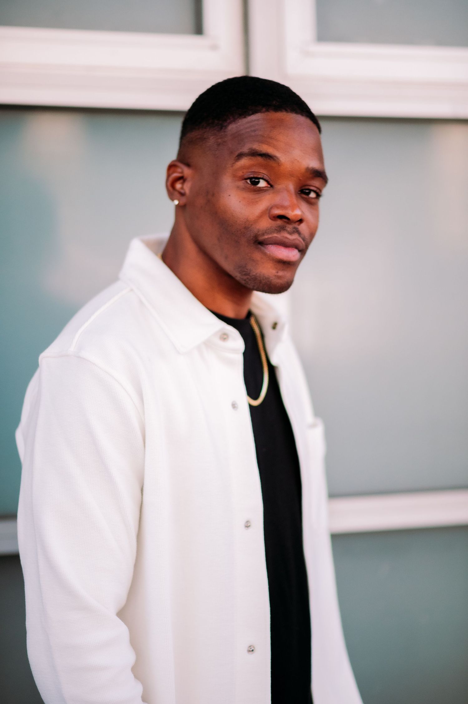 A series of profile photos showing someone wearing a white blazer and black shirt against a light gray background.
