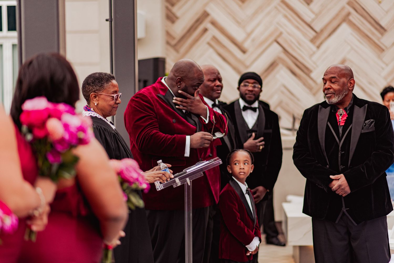 Wedding party members share joyful moments during an elegant indoor celebration.