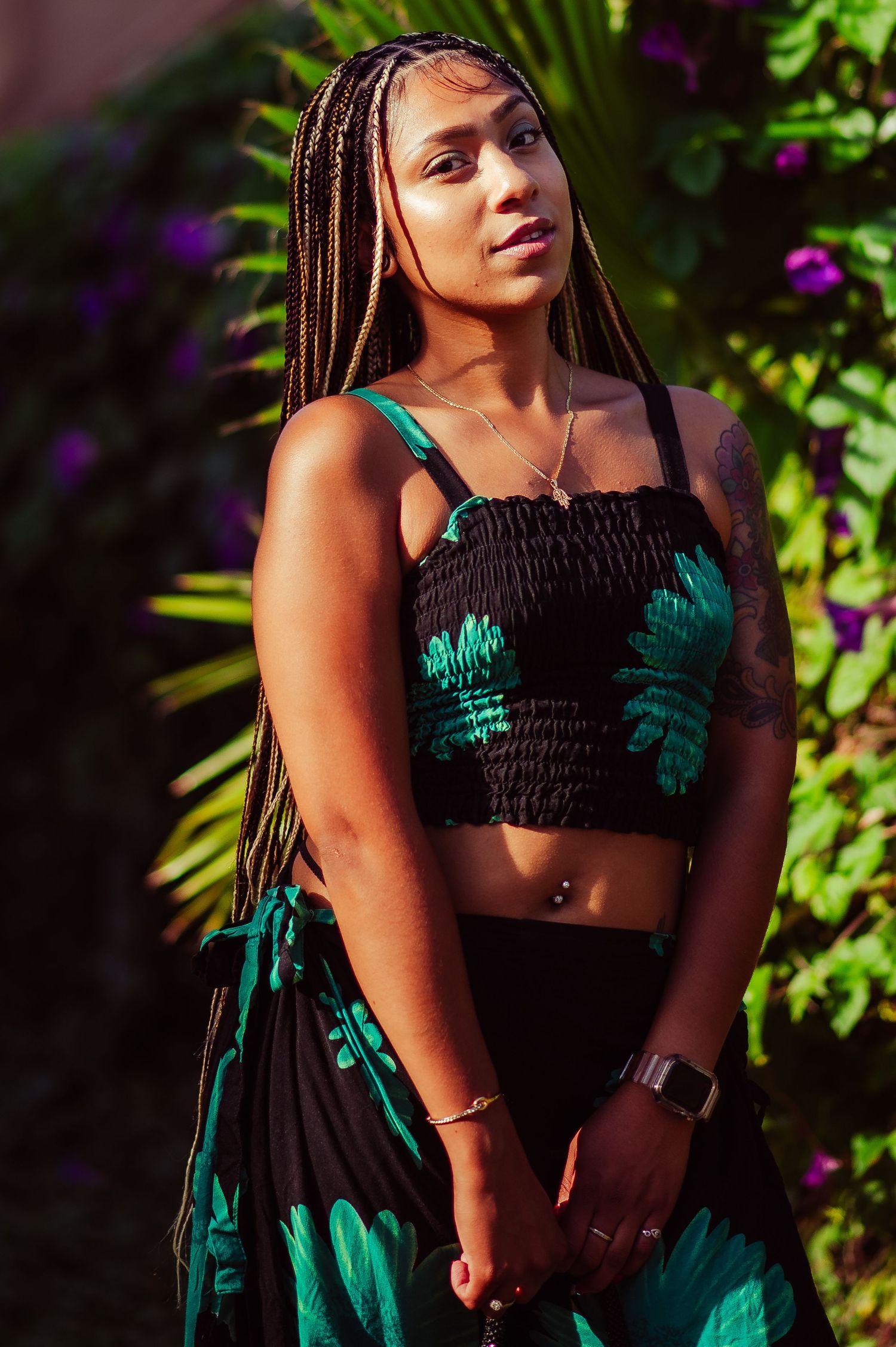 Vibrant garden photoshoot featuring a two-piece outfit with emerald palm leaf designs.