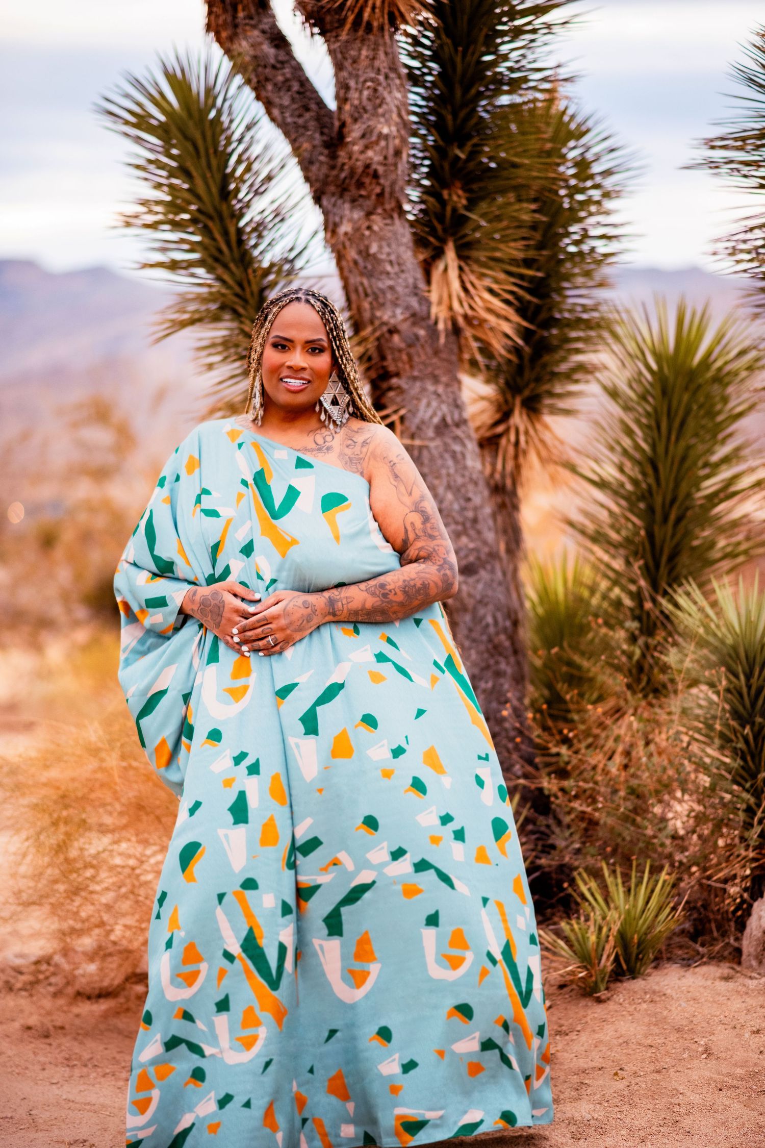 A turquoise dress with yellow patterns flows gracefully among desert yucca plants.