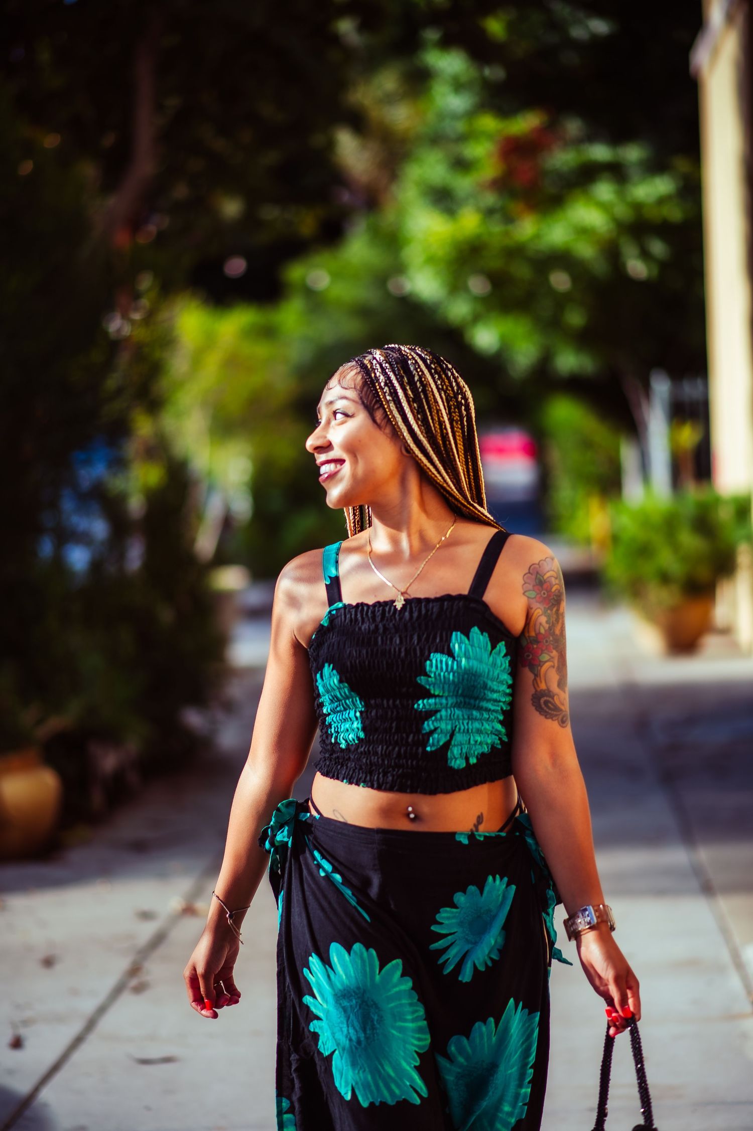 Candid outdoor portrait showcasing a vibrant black and turquoise floral summer outfit.