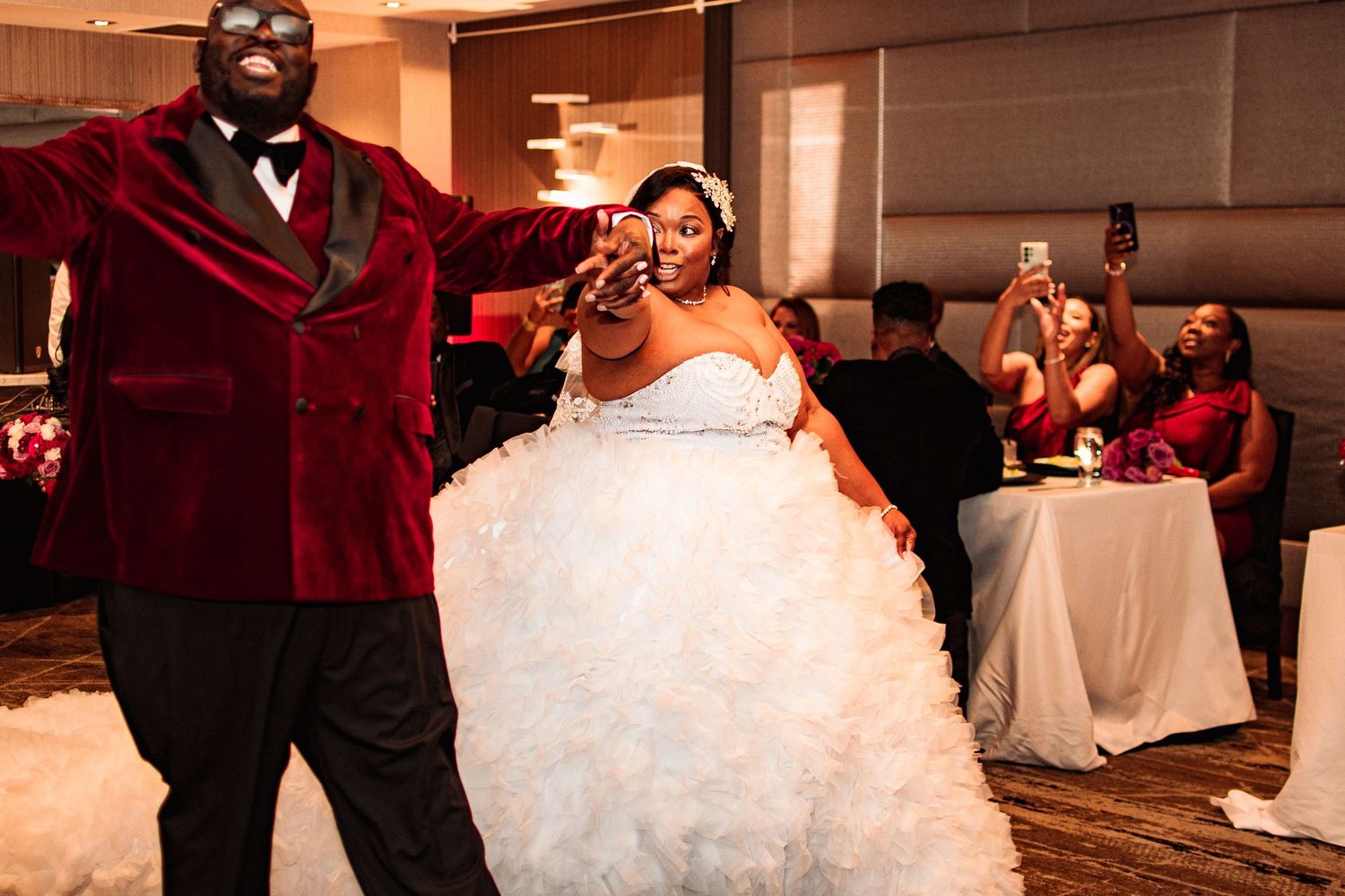 Wedding reception celebration with bridal party dancing and celebrating in an elegant indoor venue.