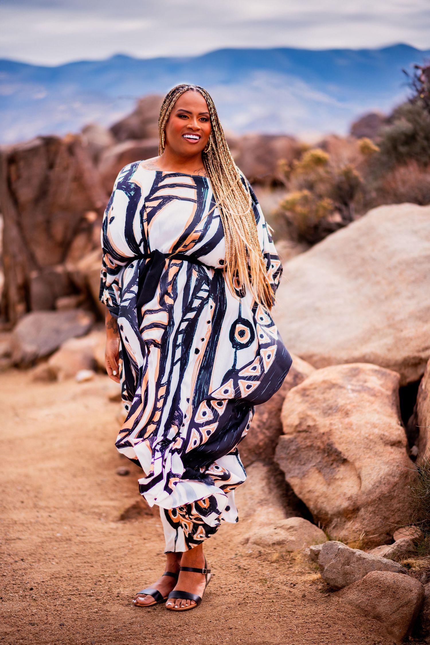 Flowing black and white geometric print dress photographed against rocky desert backdrop.