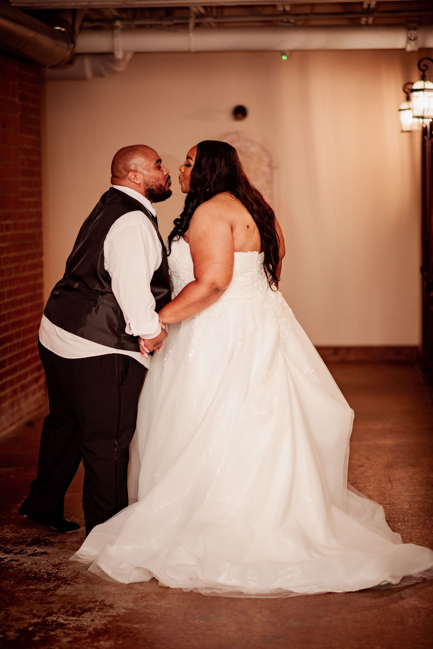 Romantic couple portrait session with white wedding dress against industrial backdrop.