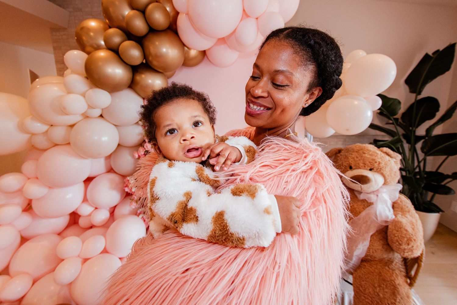 A festive celebration scene with pink and gold balloon decorations.