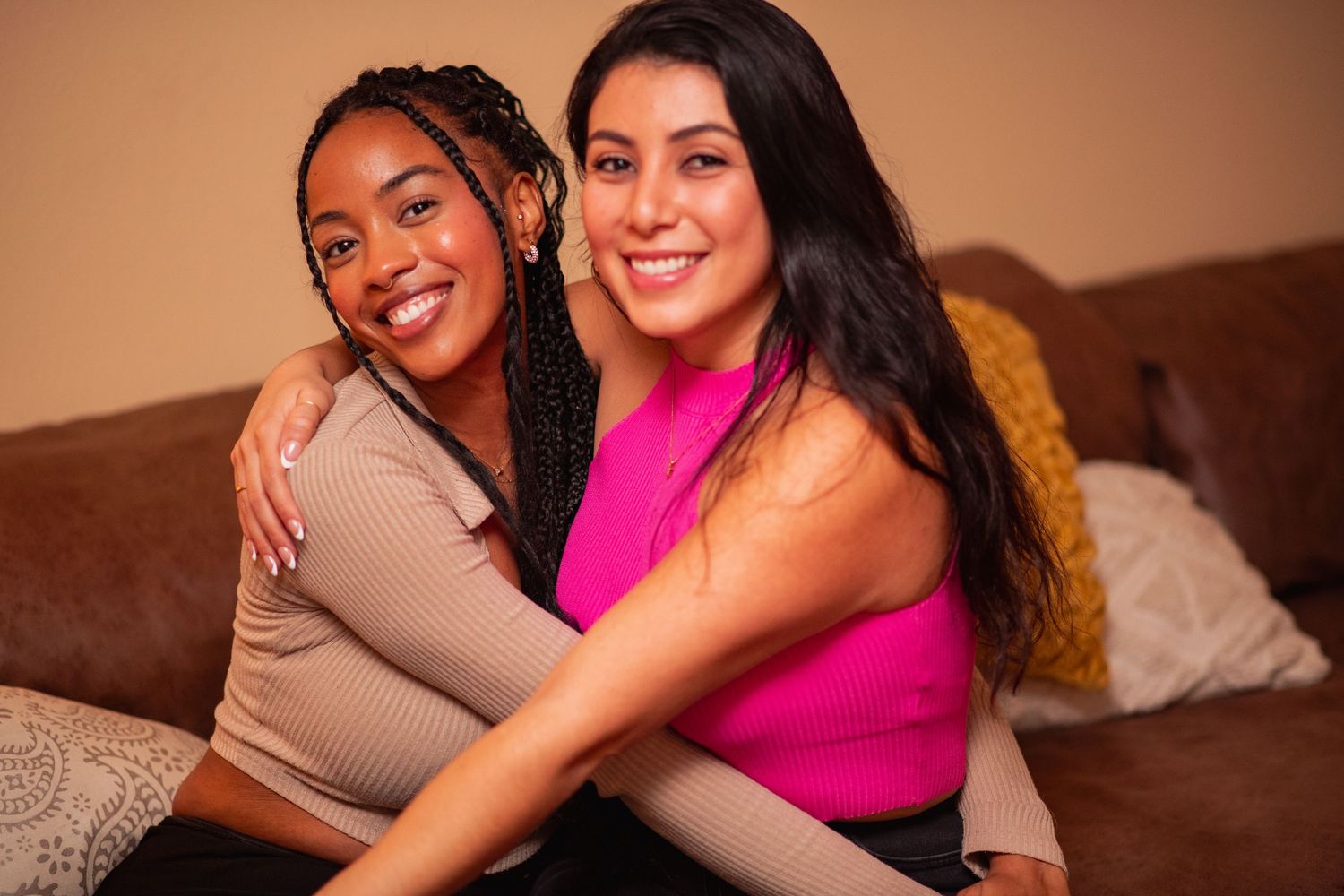 Close friends sharing warm embraces and smiles during a casual indoor celebration.
