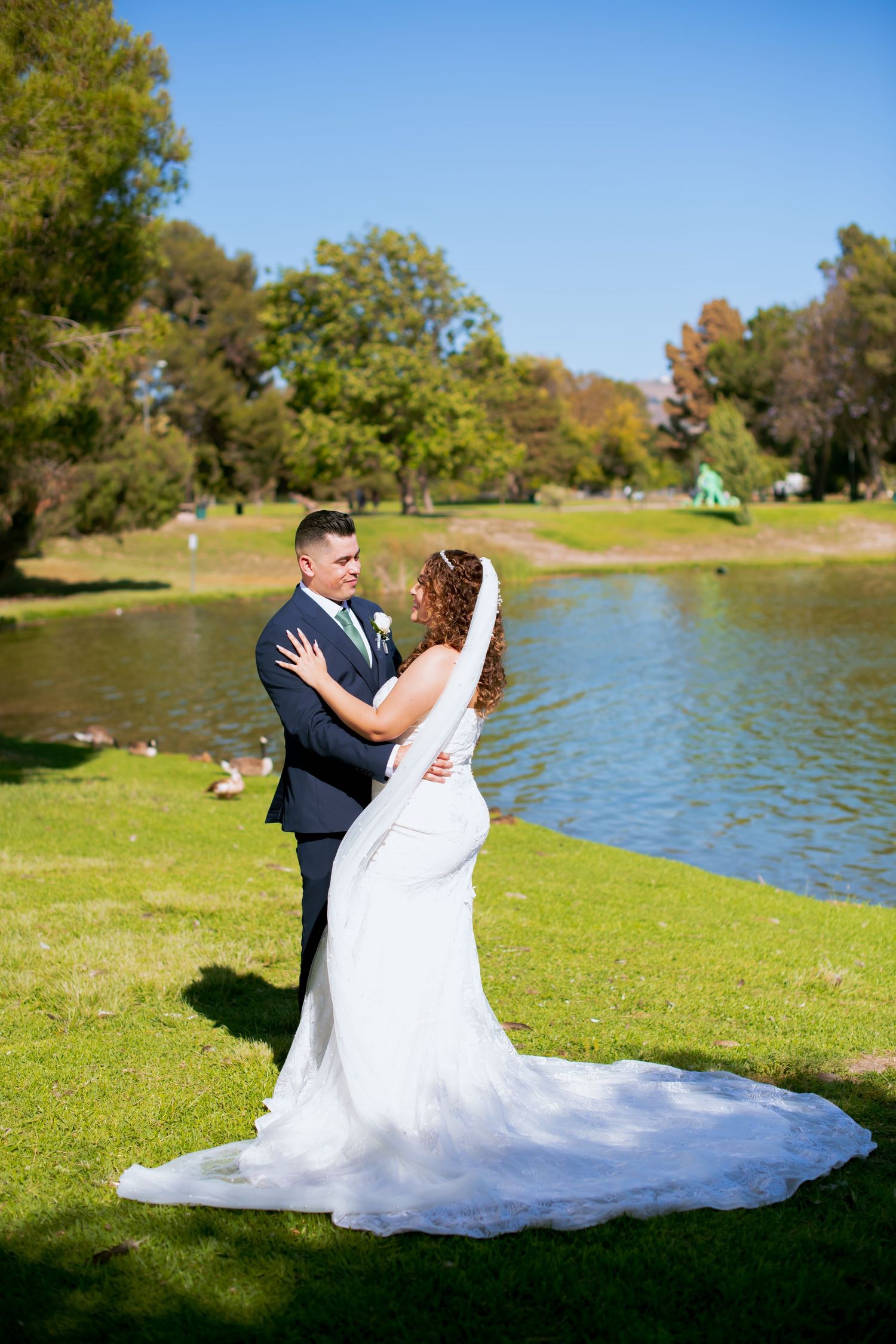 Beautiful wedding photo with Legg lake and autumn trees creating scenic natural backdrop.