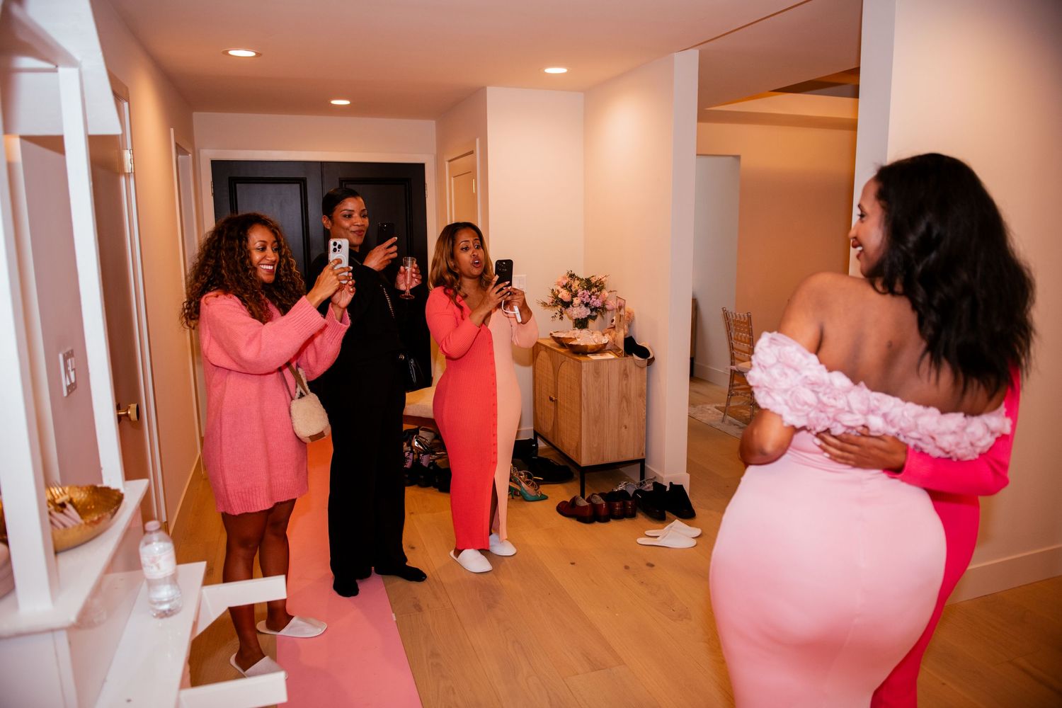 Group celebration in a hallway decorated with pink details.