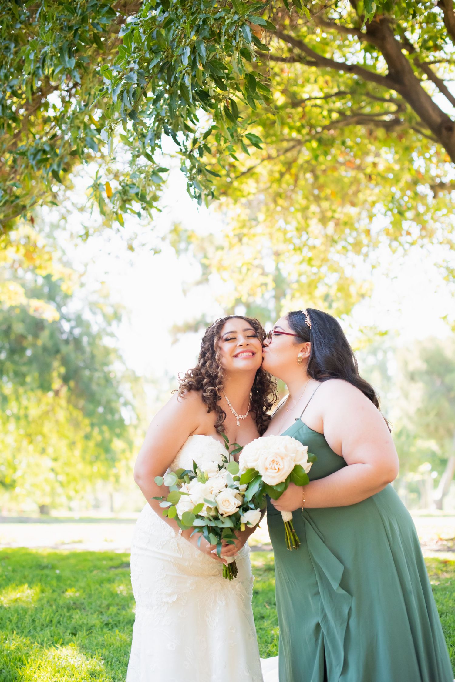 Sweet candid moment between two bridal party members during outdoor photo session.