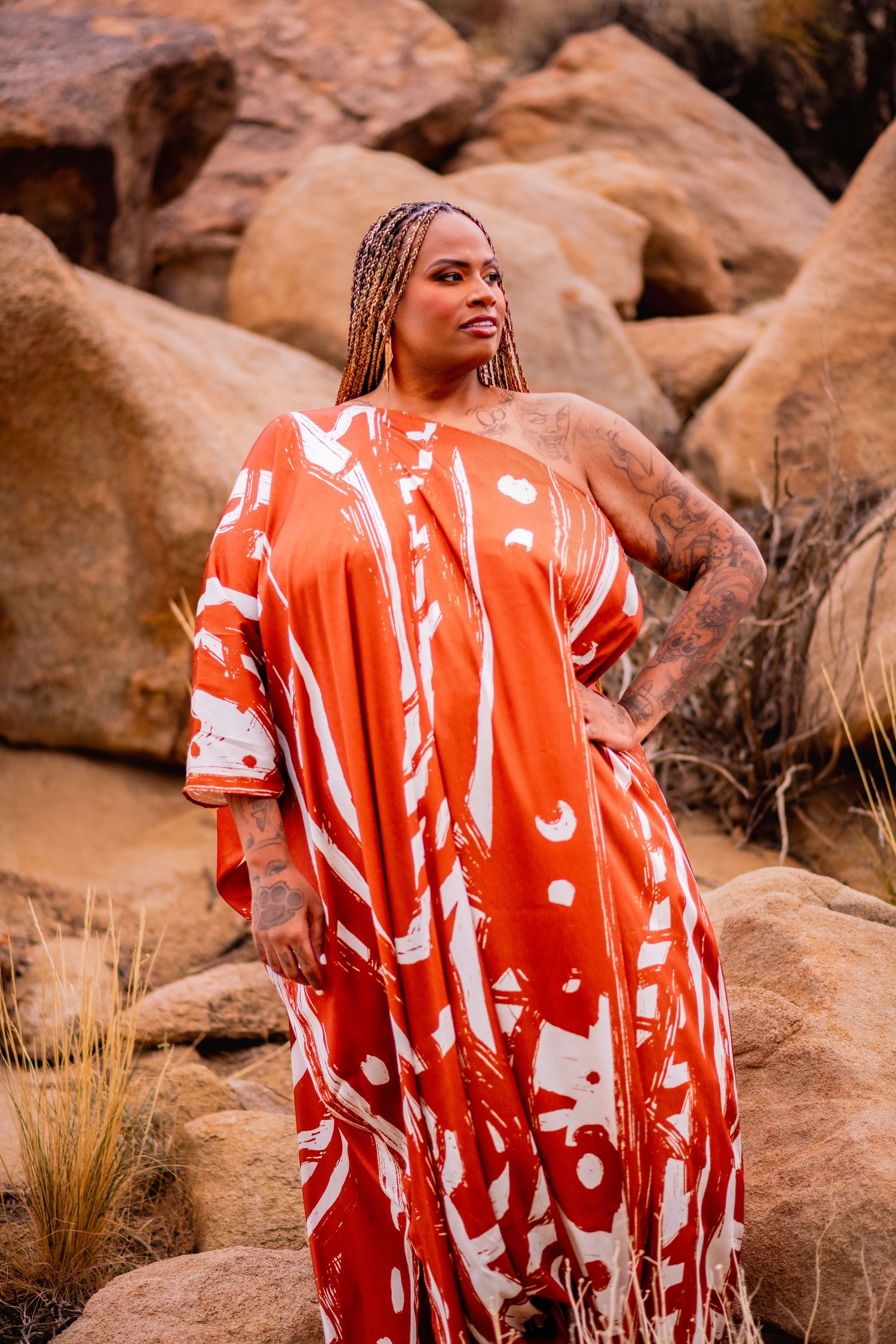 Orange and white patterned dress photographed among desert rocks at sunset.