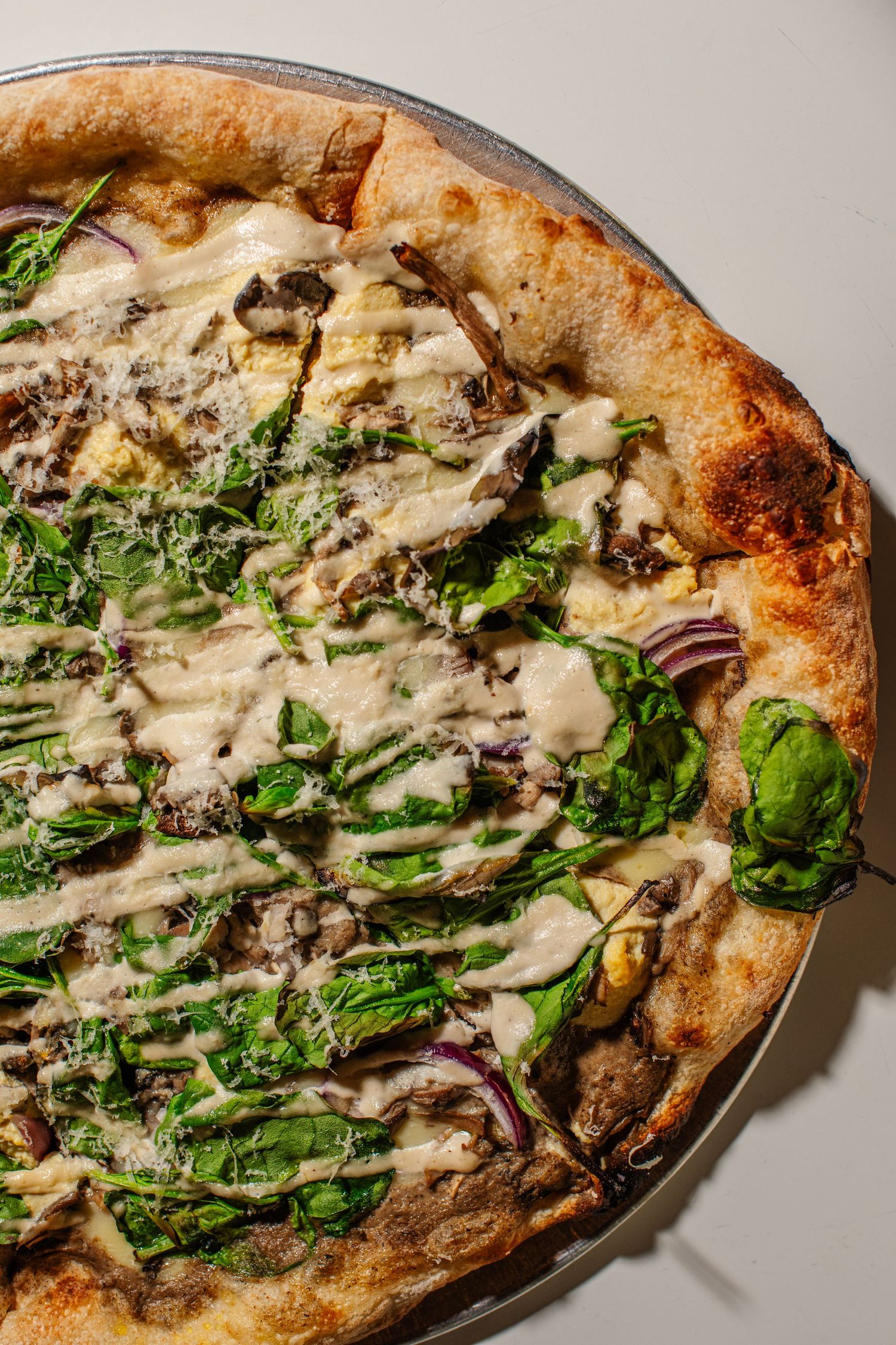 Artisanal pizza topped with melted cheese, sautéed mushrooms, and fresh arugula on rustic crust.