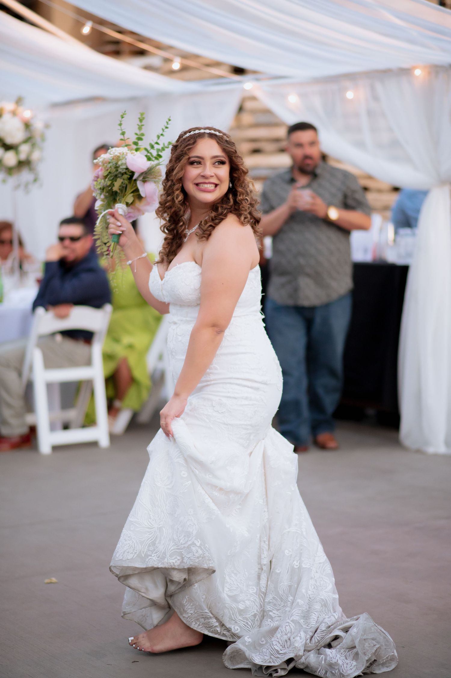 A joyful celebration on the dance floor at a wedding reception with a flowing white dress in motion.