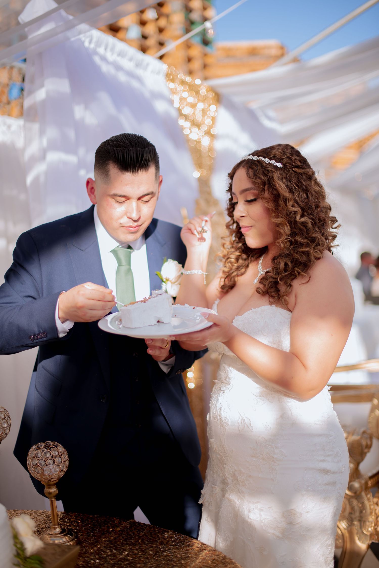 Wedding couple playfully feeding each other cake at their reception.
