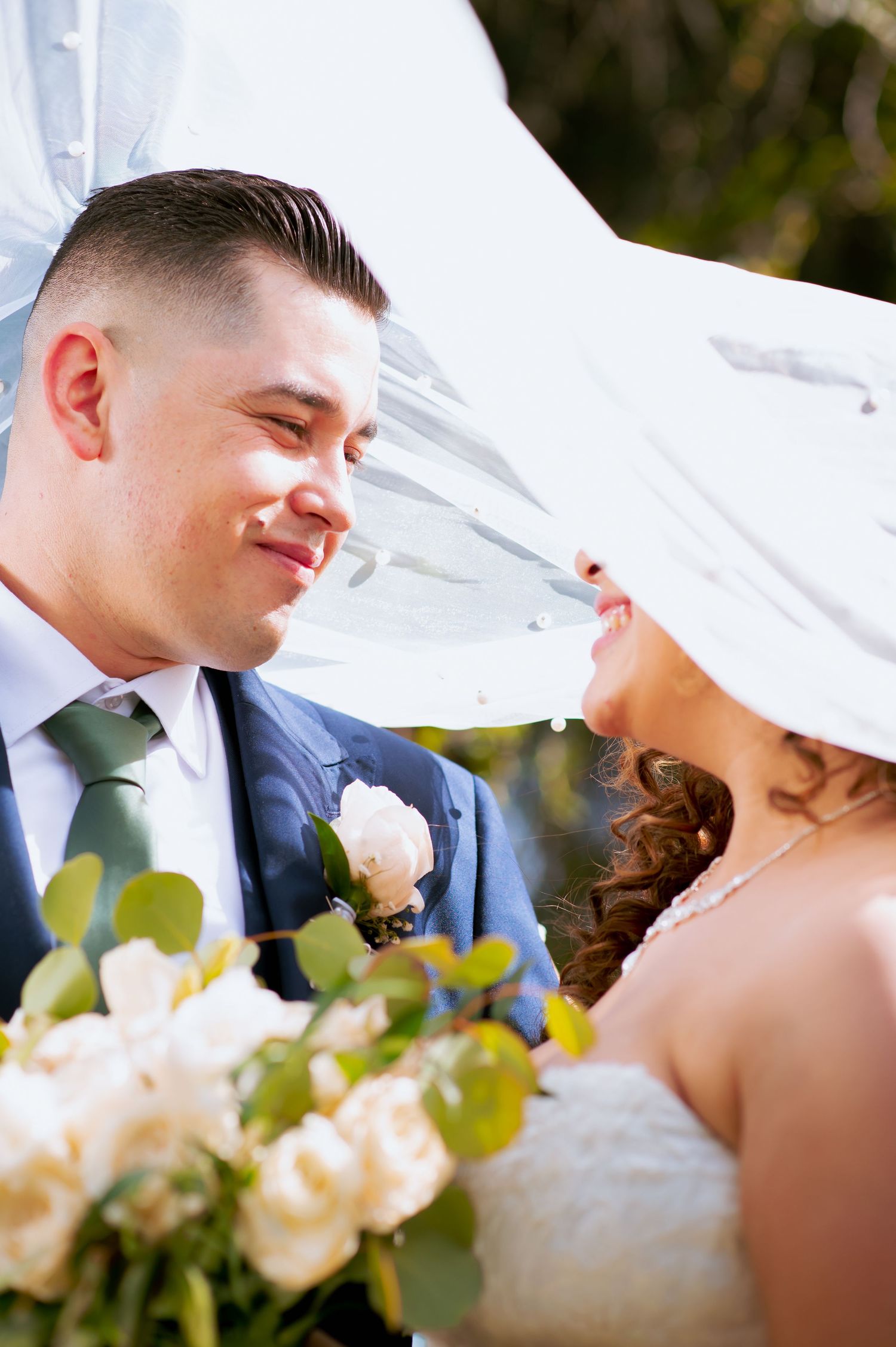 Close-up wedding portraits with flowing veil and soft focus bouquet details.
