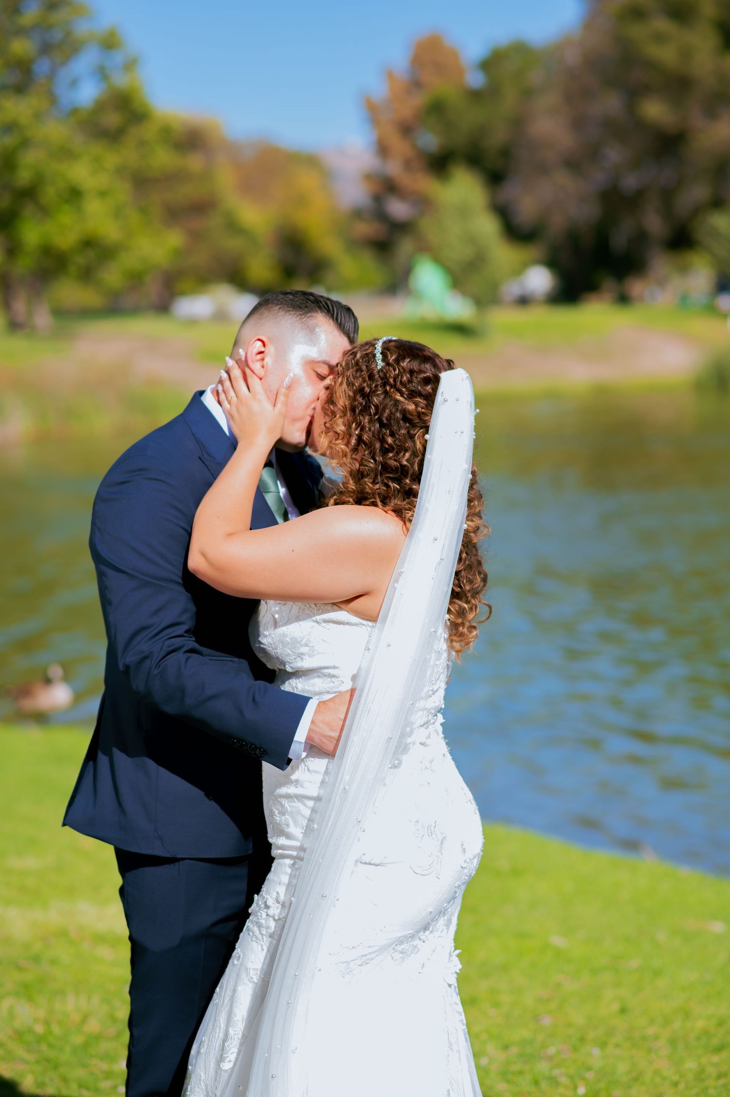 Elegant outdoor wedding photography session with couple by waterfront.