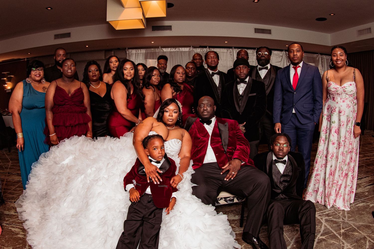 Wedding reception celebration with guests in formal attire gathered in elegant indoor venue.