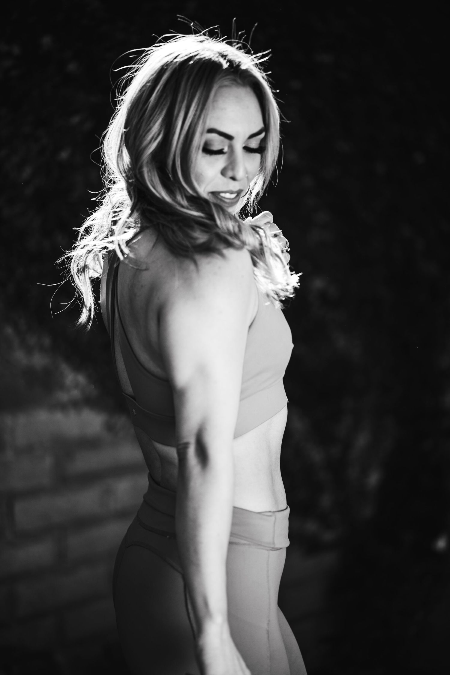Black and white portrait showing elegant pose with dramatic lighting and shadows.