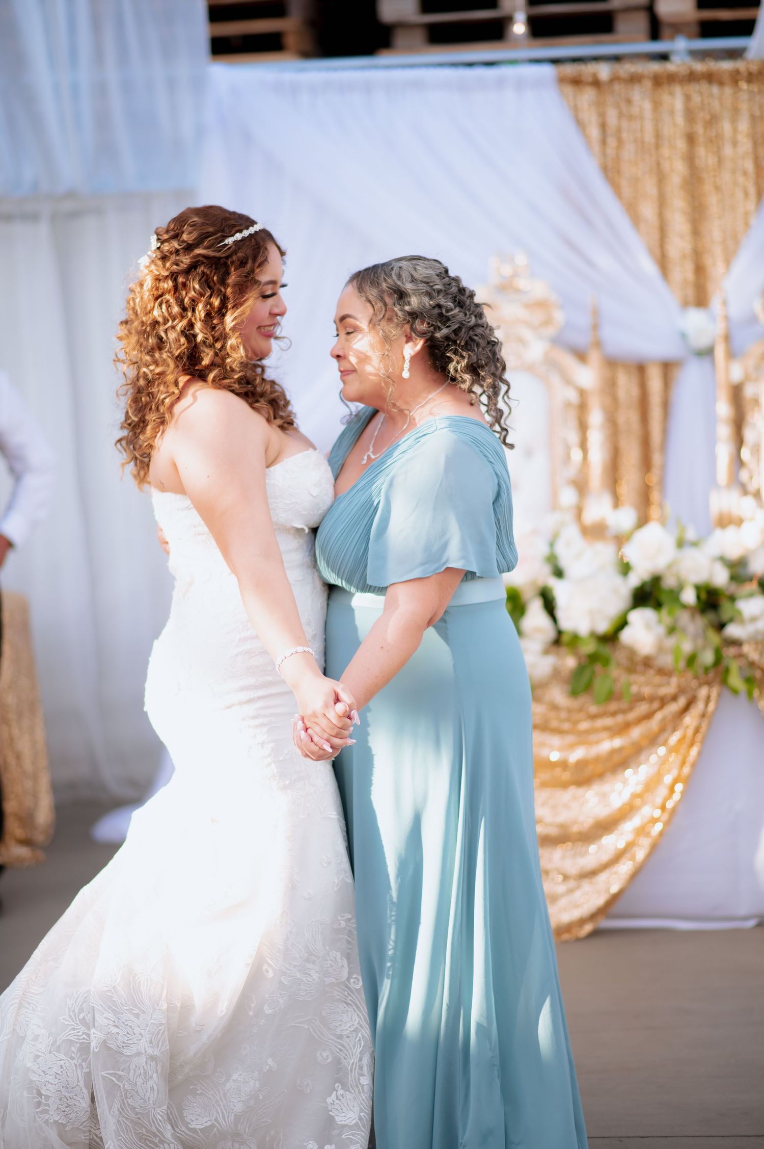 Dancing at wedding reception with someone in light blue dress and white wedding gown.