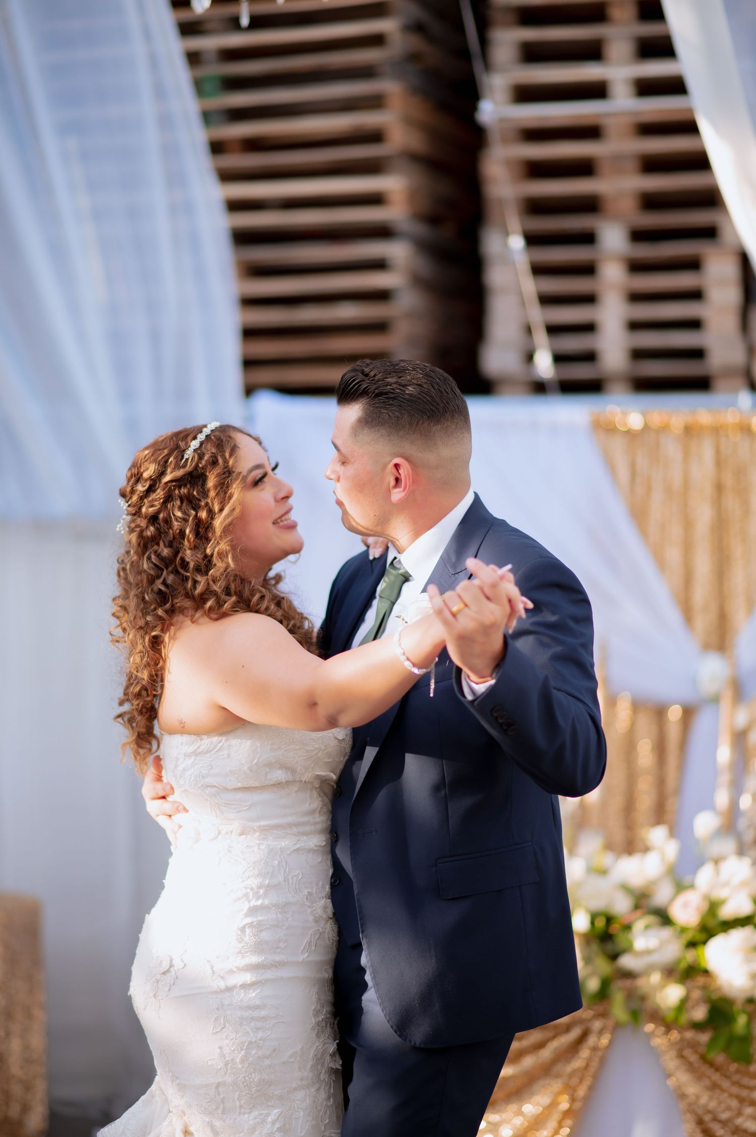 Couple shares a romantic moment during their first dance at an elegantly decorated wedding venue.