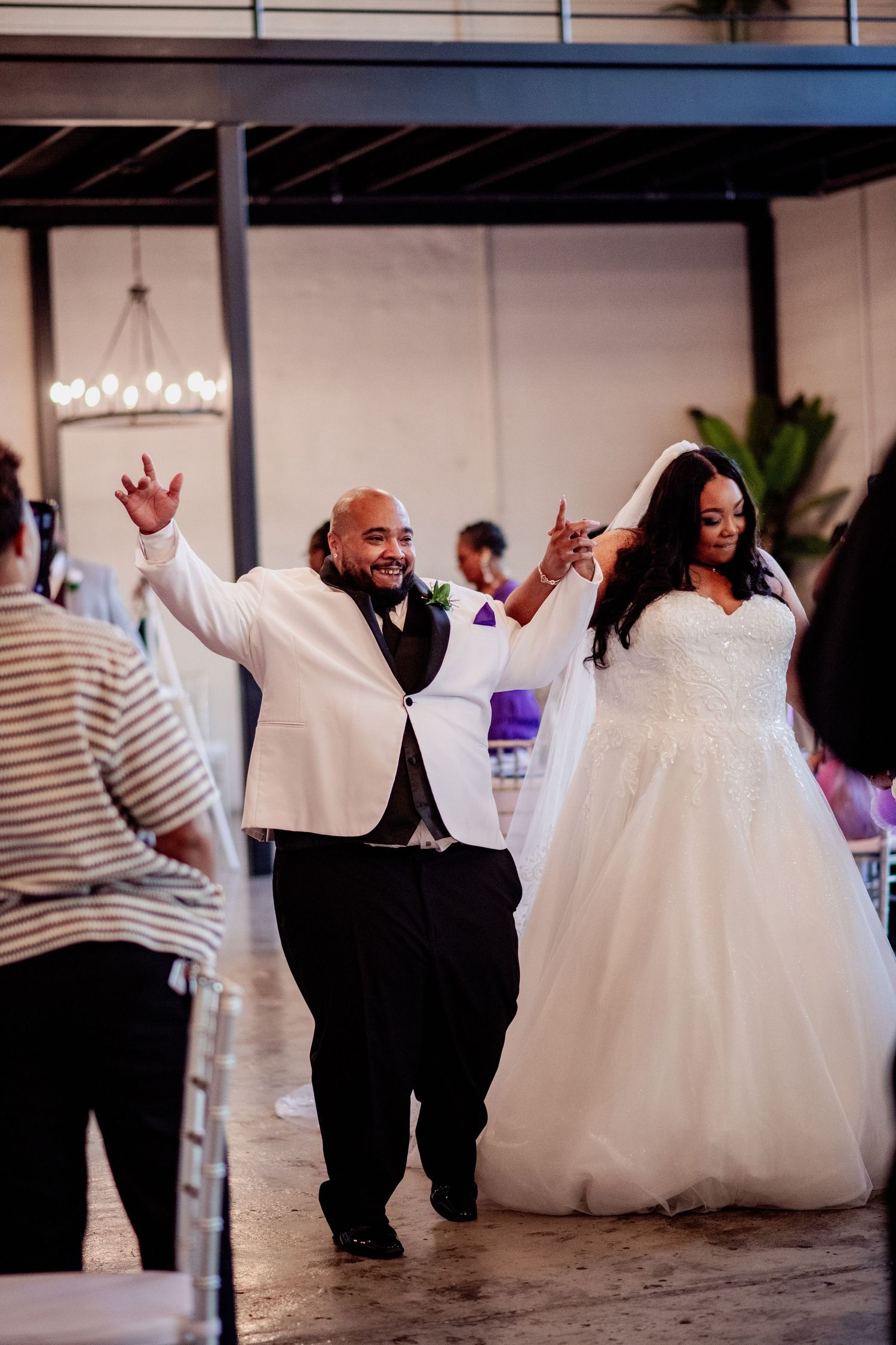 Couple dances joyfully during wedding celebration, with bride's white ballgown dress twirling across dance floor.