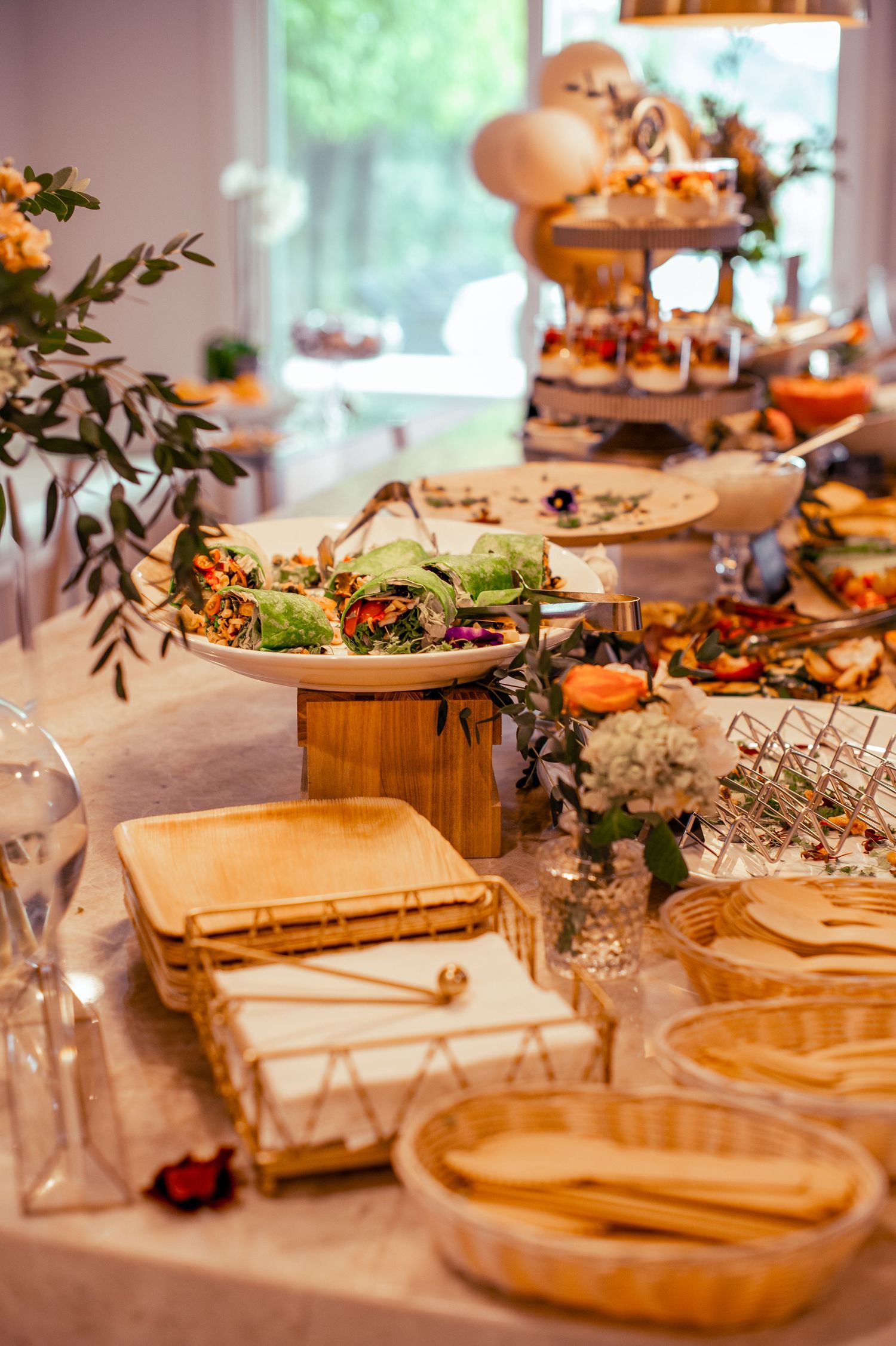 Rustic wooden serving boards displaying appetizers and snacks at an elegant party setup.