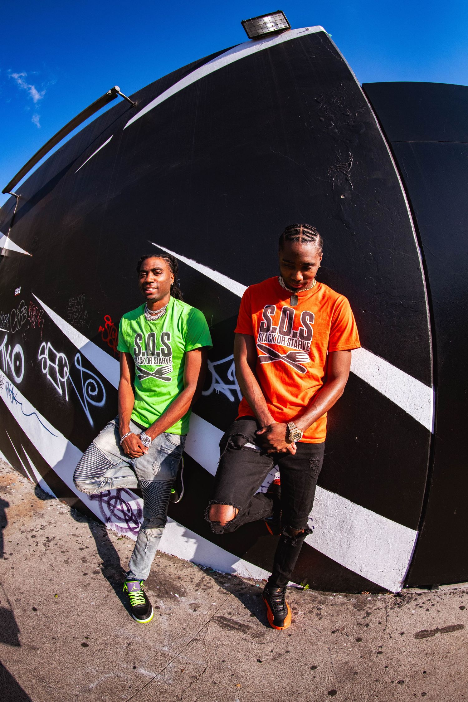 Urban photo series against black wall with subjects wearing bright colored shirts in fisheye perspective.