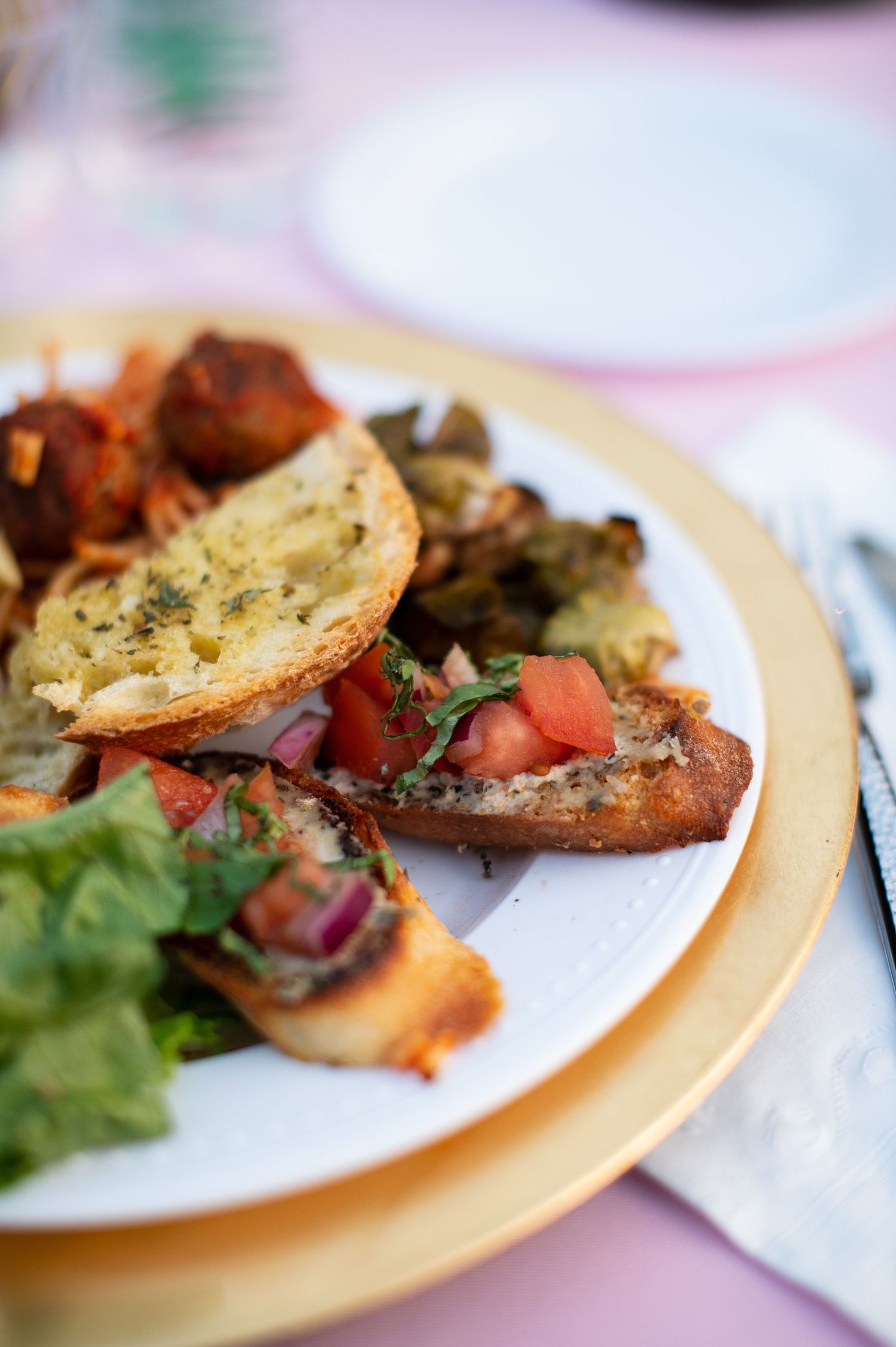 A plate of bruschetta topped with fresh tomatoes, herbs and garlic bread served with a side salad.