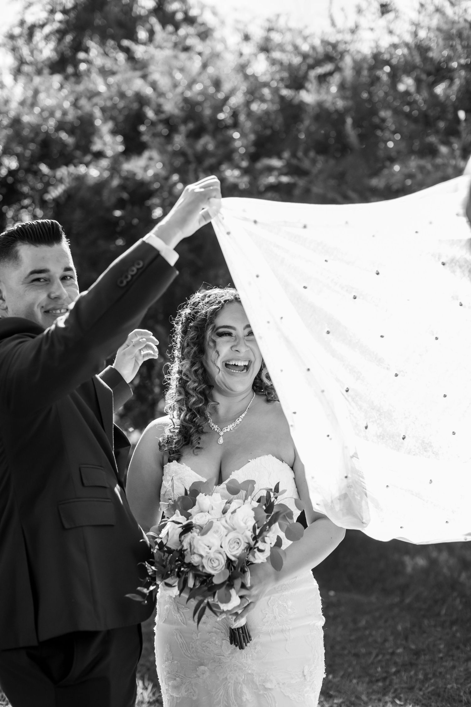 Black and white wedding sequence showing playful moments with flowing veil in natural light.