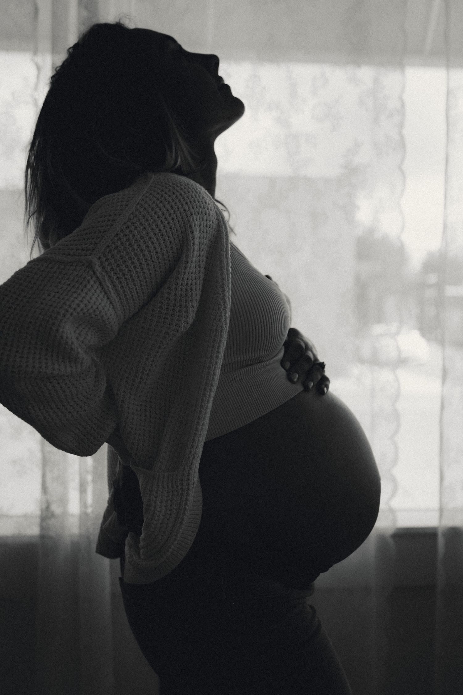 Silhouetted maternity photos showing the profile of a pregnant belly against a light background.
