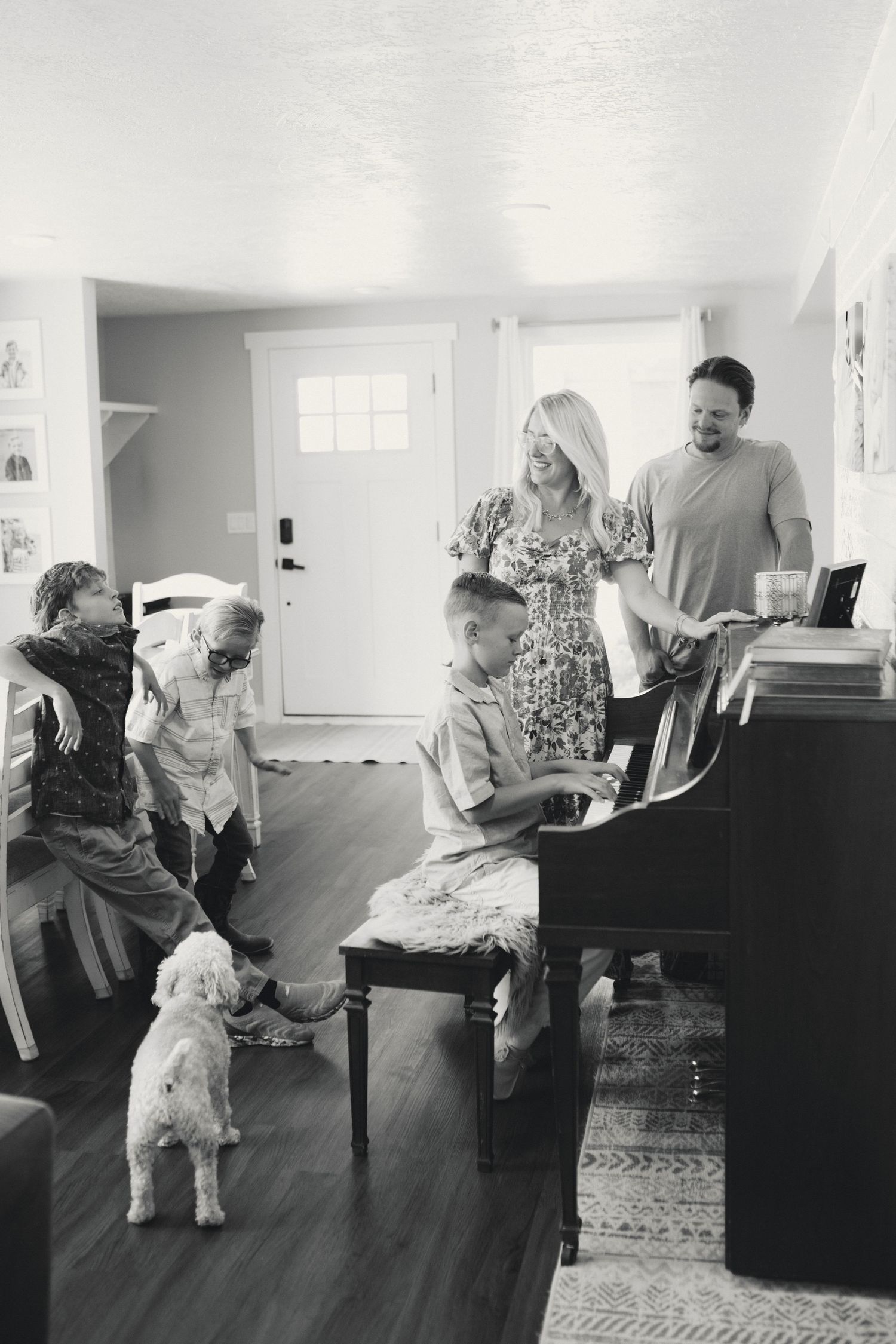 A series of four black and white photographs showing people sitting and interacting together in a living room setting.