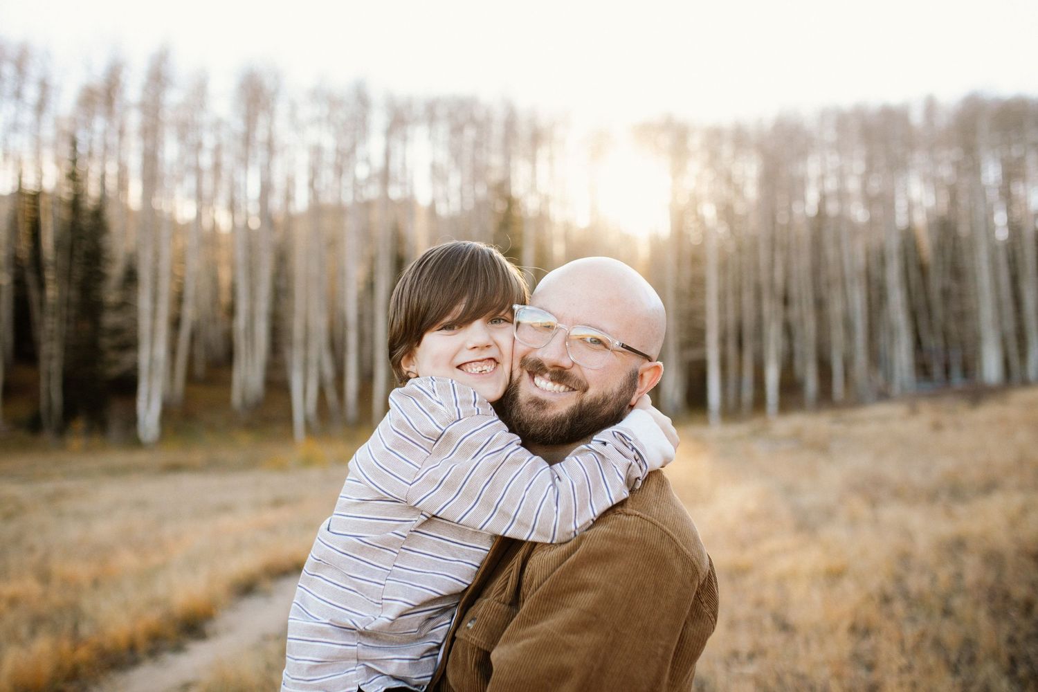 Candid moments captured between loved ones in a beautiful aspen grove at sunset.