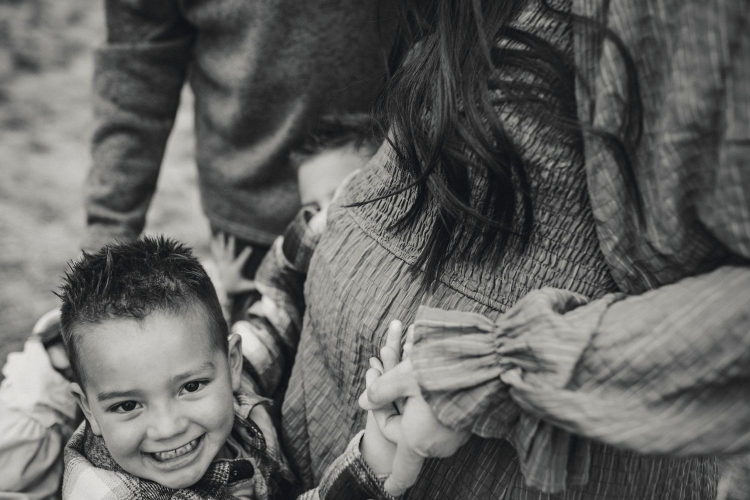 A candid black and white photograph capturing a joyful family moment.