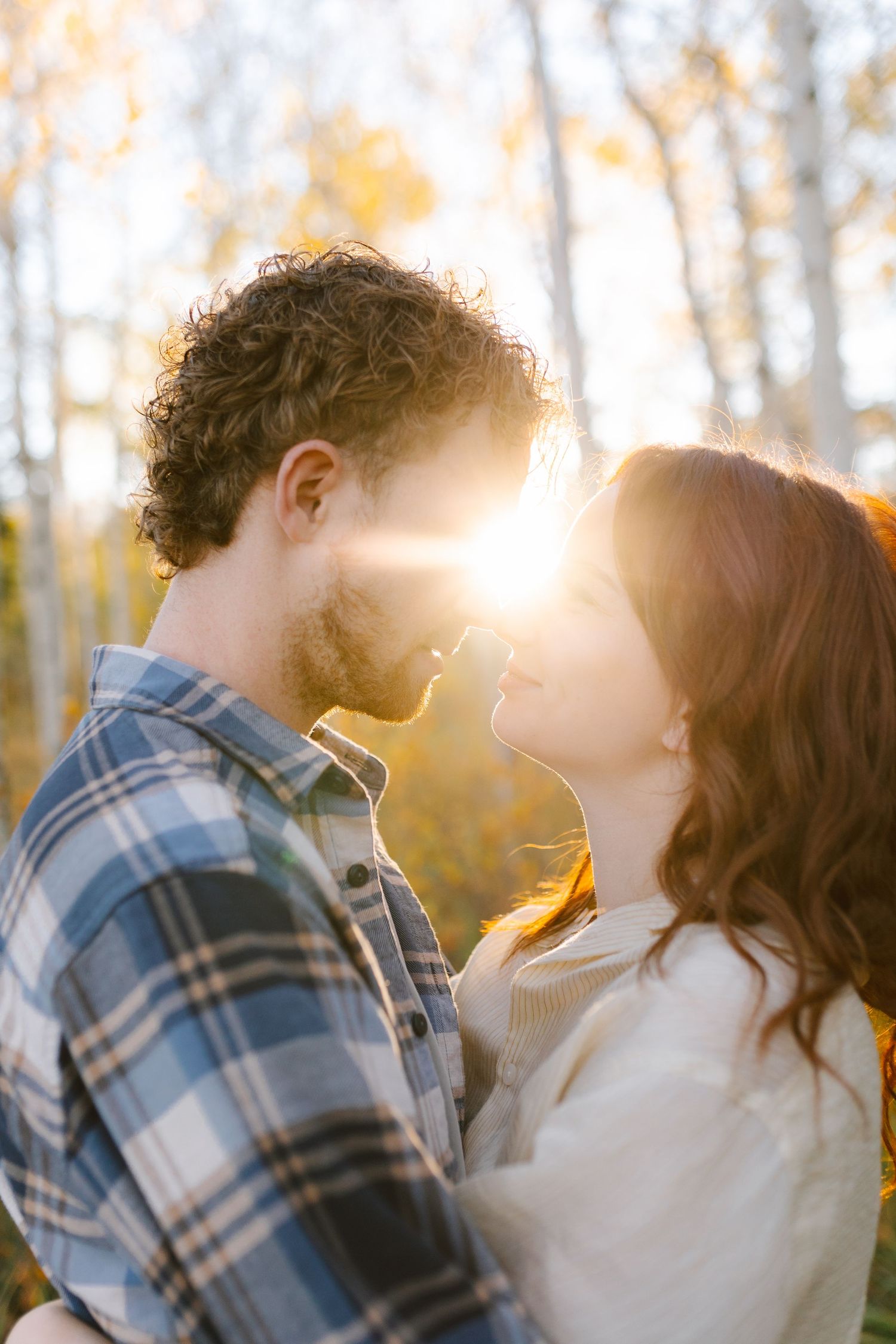 Intimate close-up moments between couple in golden forest light.