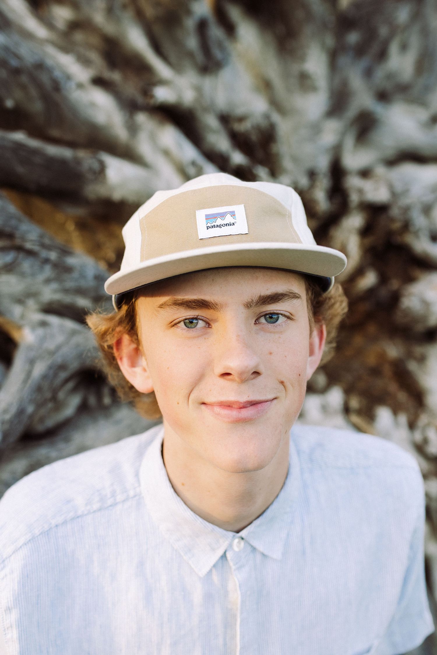 Person wearing a white baseball cap and shirt in a casual outdoor portrait series.