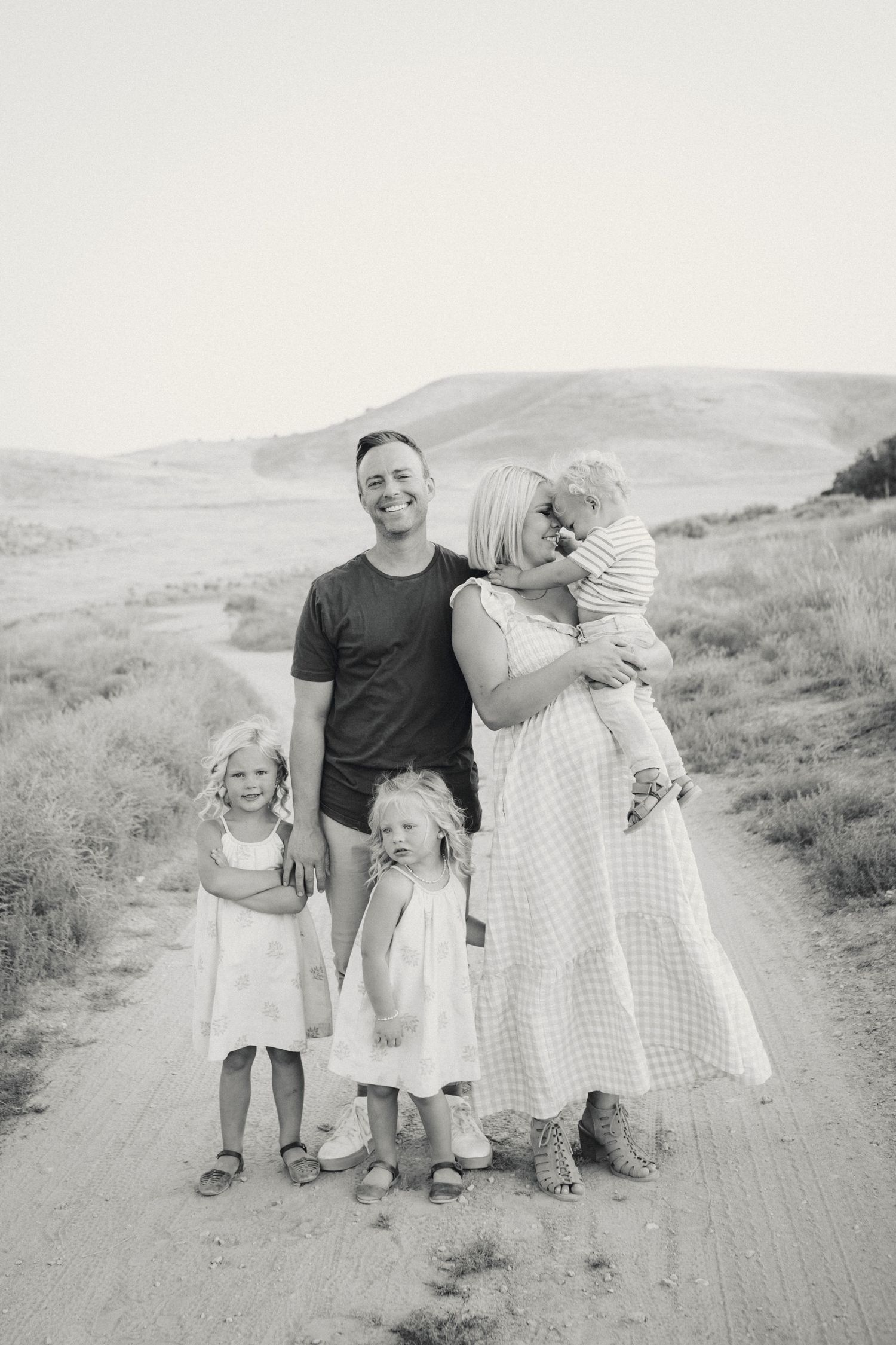 Family walking together on a dirt path in black and white.