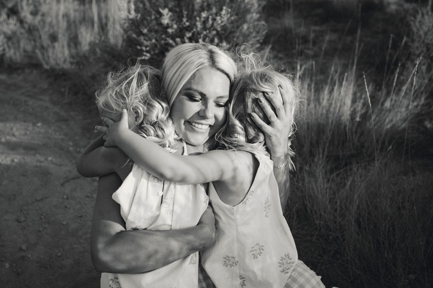 Intimate black and white family portraits showing tender moments outdoors.