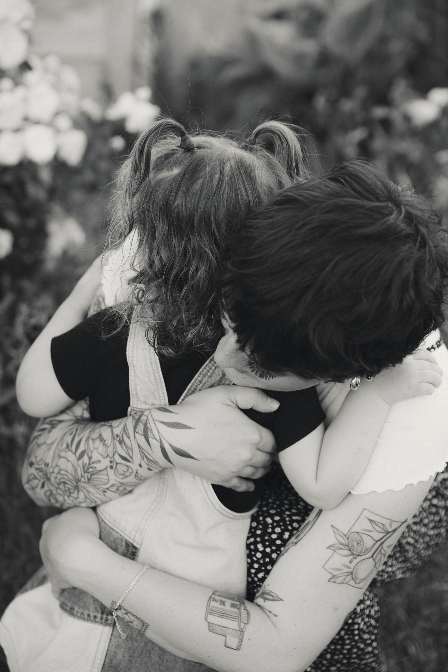 A series of black and white photos showing a tender embrace between two people in a garden setting.