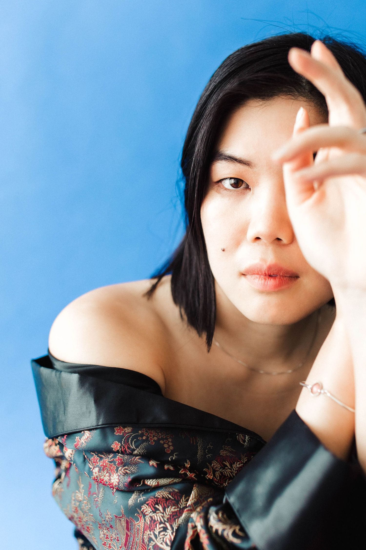 Close-up portraits with soft lighting against vibrant blue backdrop.