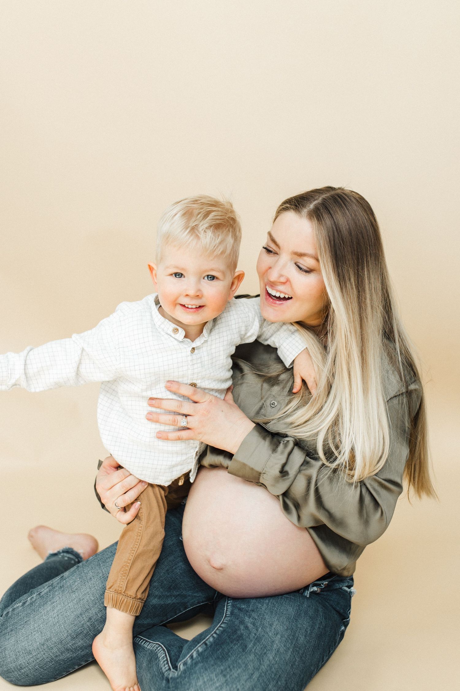 Joyful maternity moment captured with toddler and pregnant mother embracing.