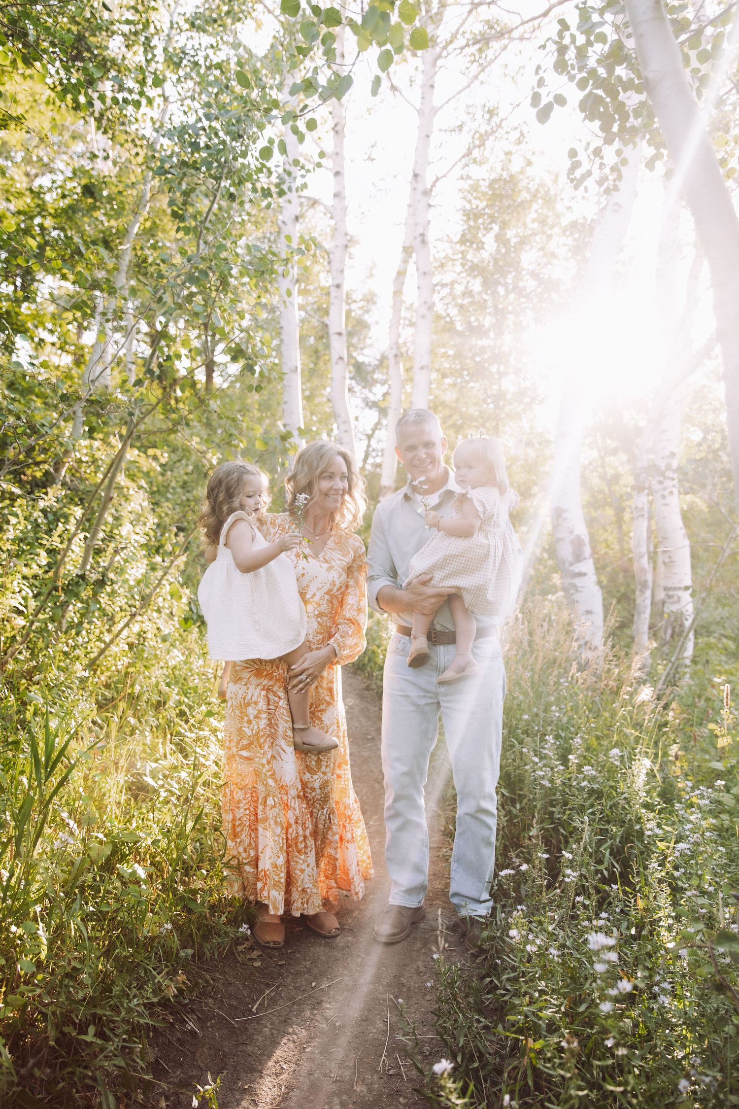 A sunny outdoor gathering among birch trees with sunlight streaming through the branches.