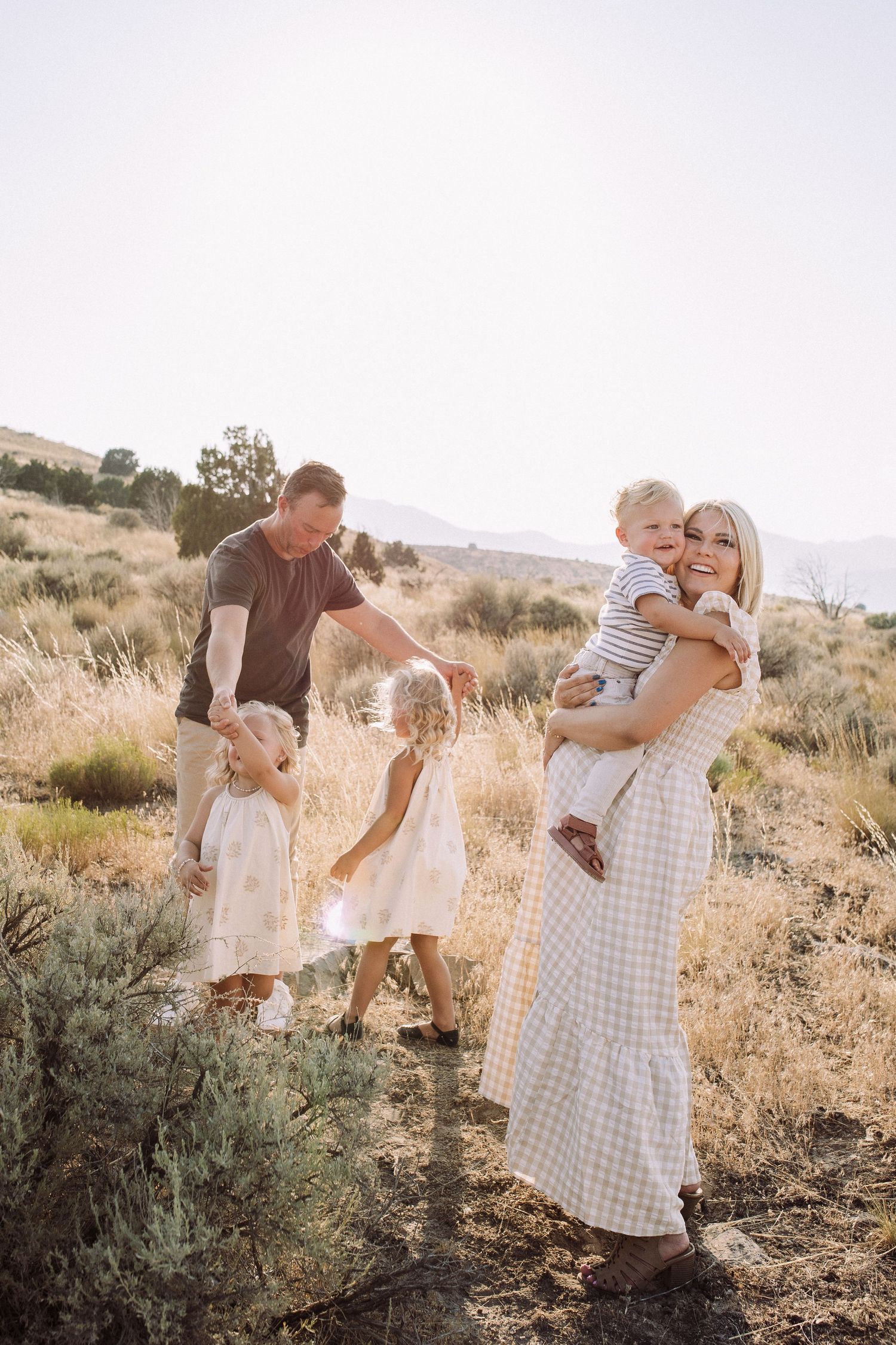 Family sharing joyful moments together in a desert setting during sunset.
