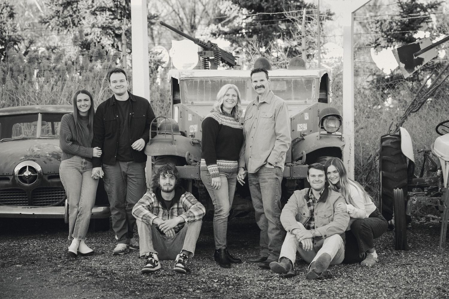 Family members relaxing on grass during outdoor photo session.