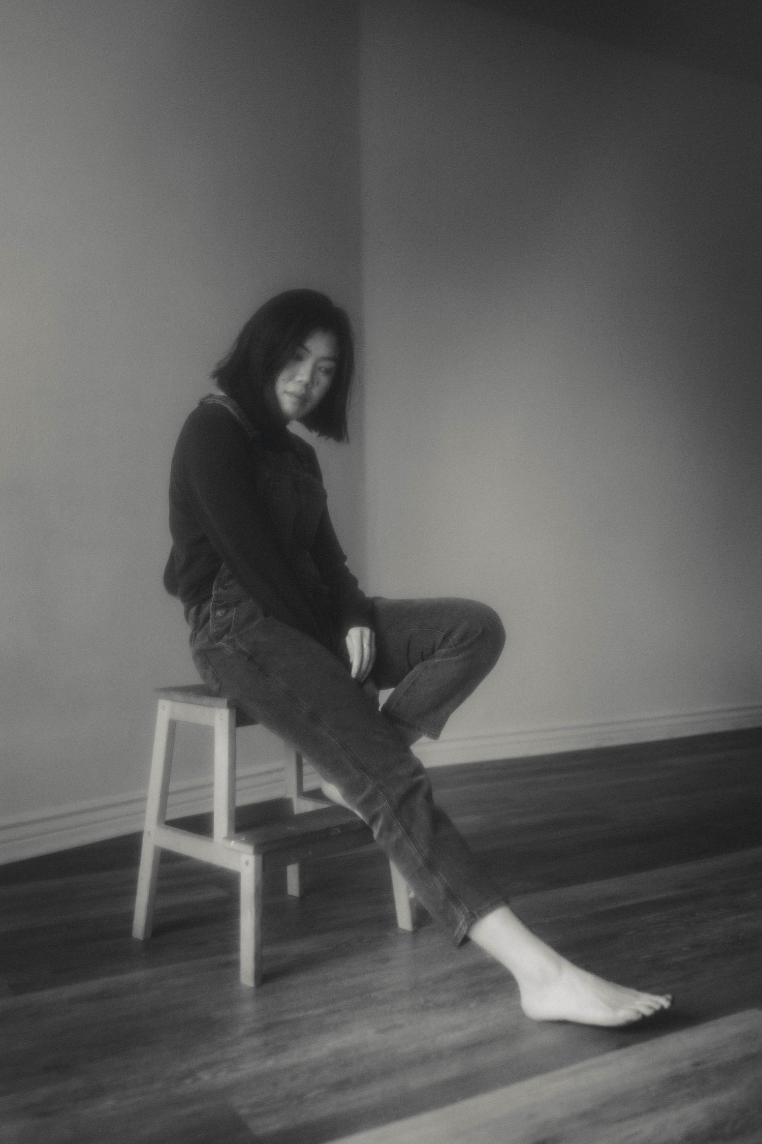 Black and white photo sequence showing movement on wooden floor with white chair.